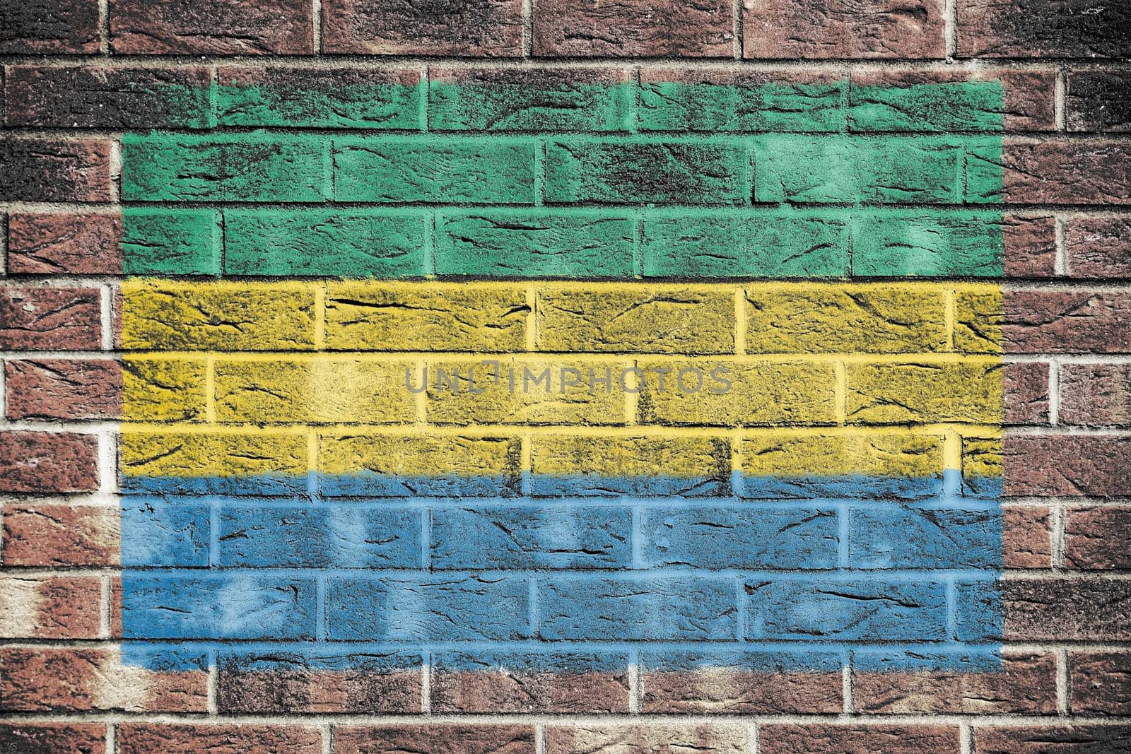 A Gabon flag painted on brick wall background