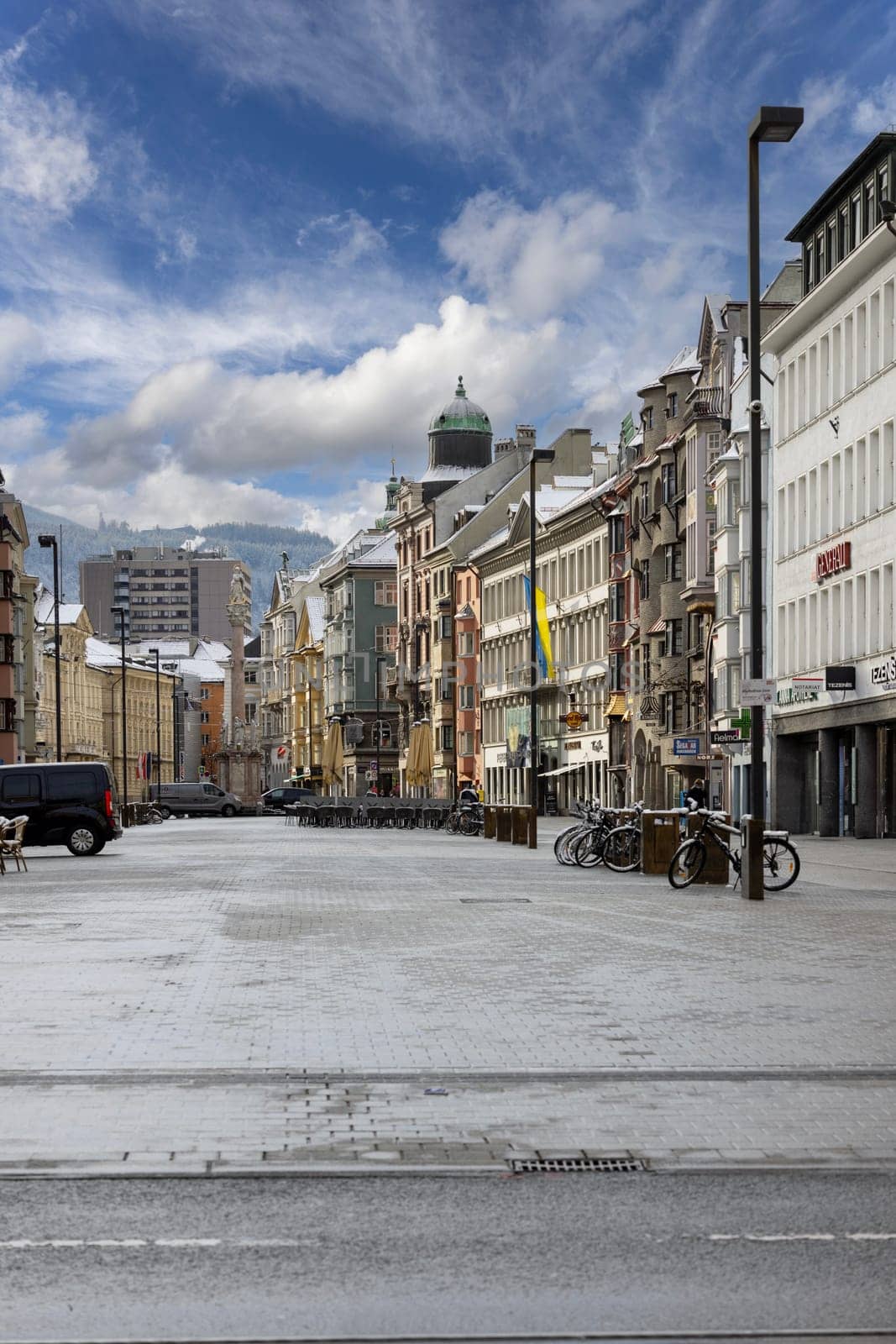 Innsbruck, Austria - February 26, 2023: View of Maria Theresa Street and Column of St. Anna. The square is surrounded by historic tenement houses