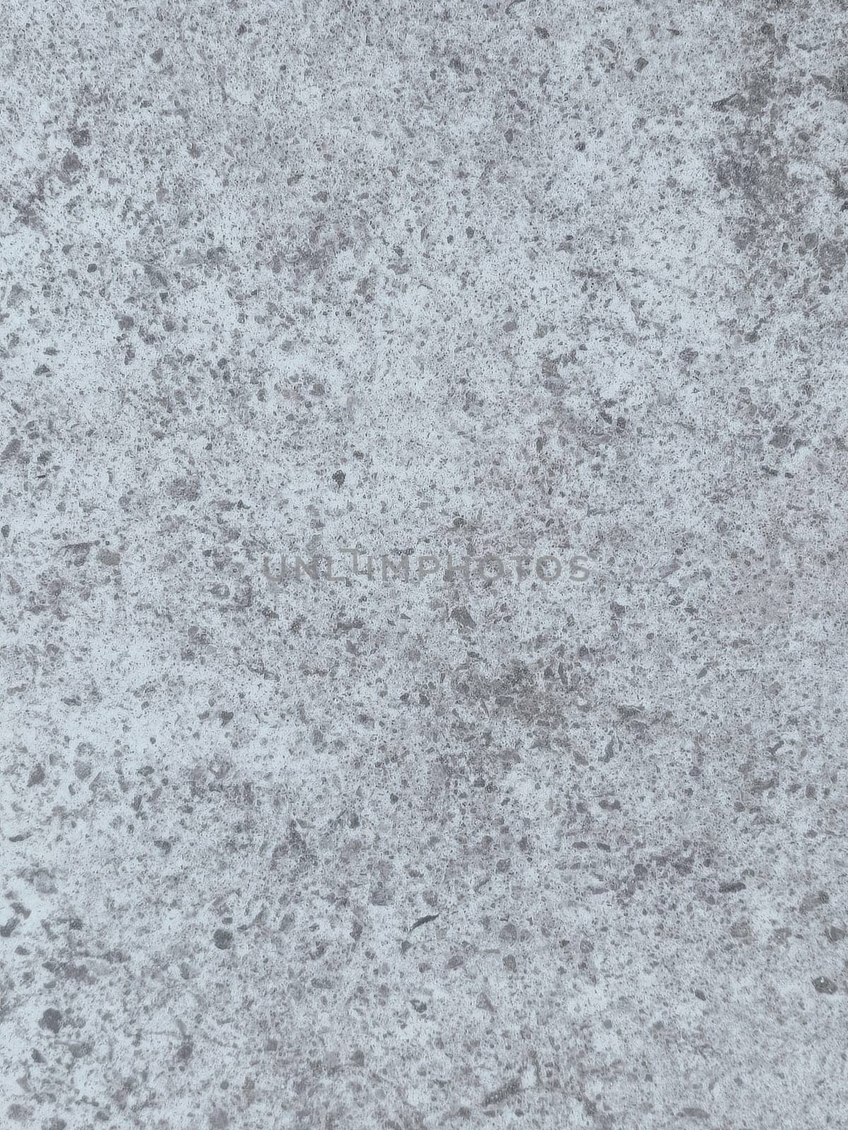 A grey and white wall with a few spots of color. The wall is made of concrete and has a rough texture