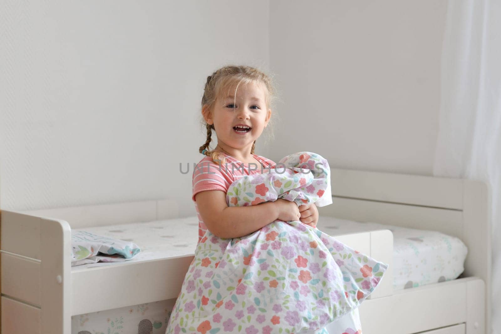 A girl makes a bed in the children room