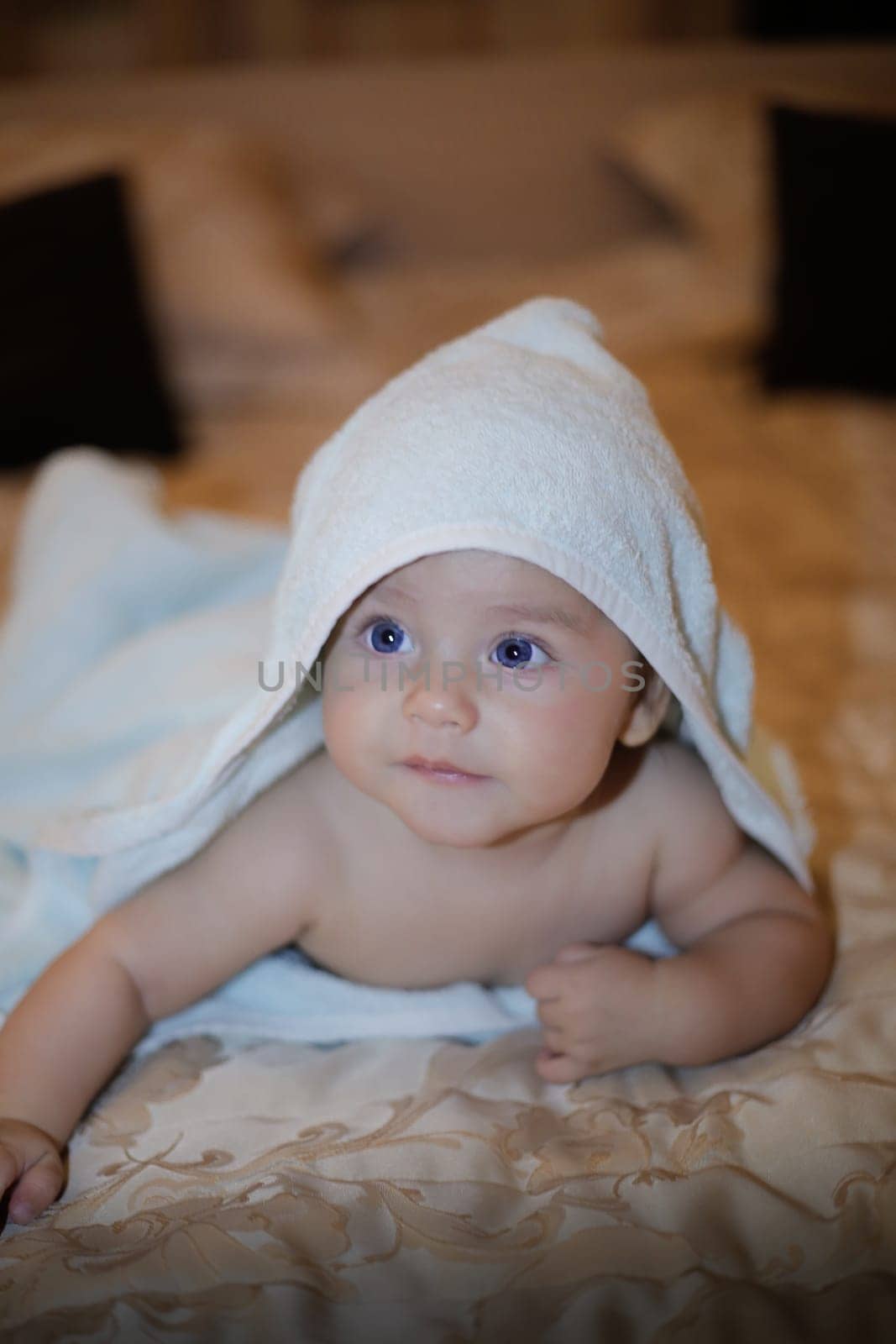 A charming baby wrapped in a fluffy towel, exuding an irresistible mix of cuteness and boundless curiosity