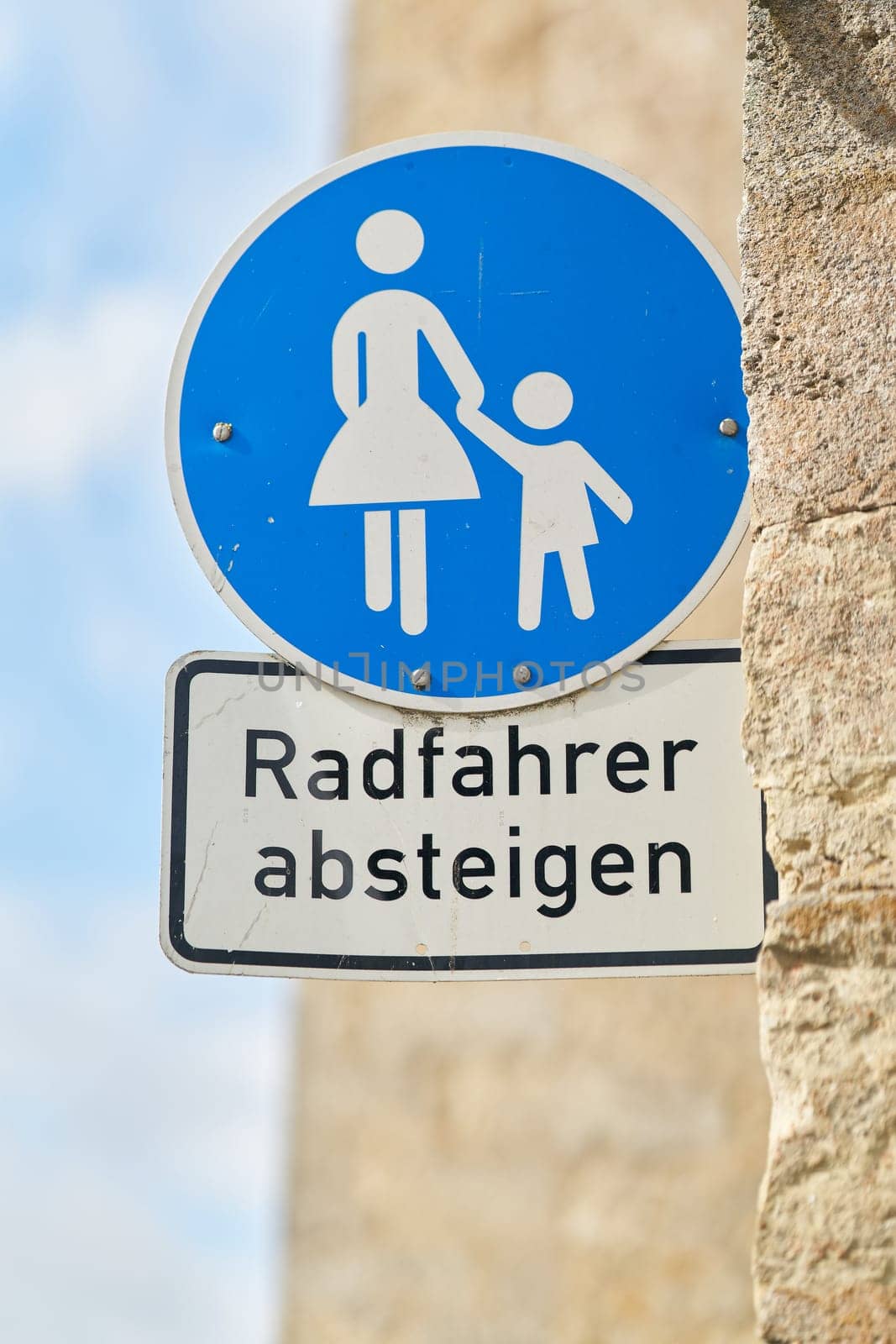 Sign in a pedestrian zone with the German inscription Radfahrer absteigen. Translation: cyclists dismount