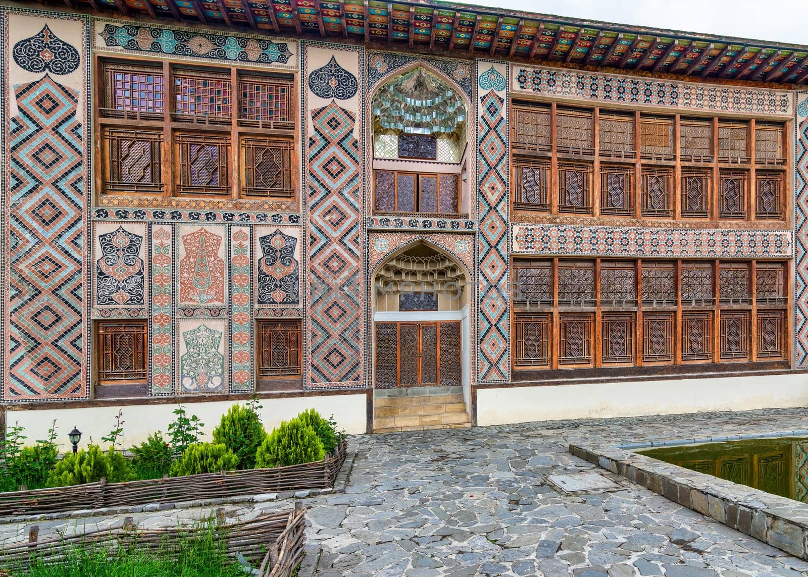 Intricate architecture of Shaki Khan's Palace, in Shaki, Azerbaijan, surrounded by lush greenery