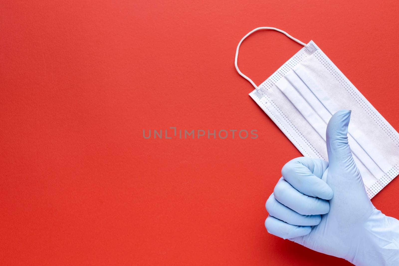 top view hand giving thumbs up with medical mask copy space. High resolution photo