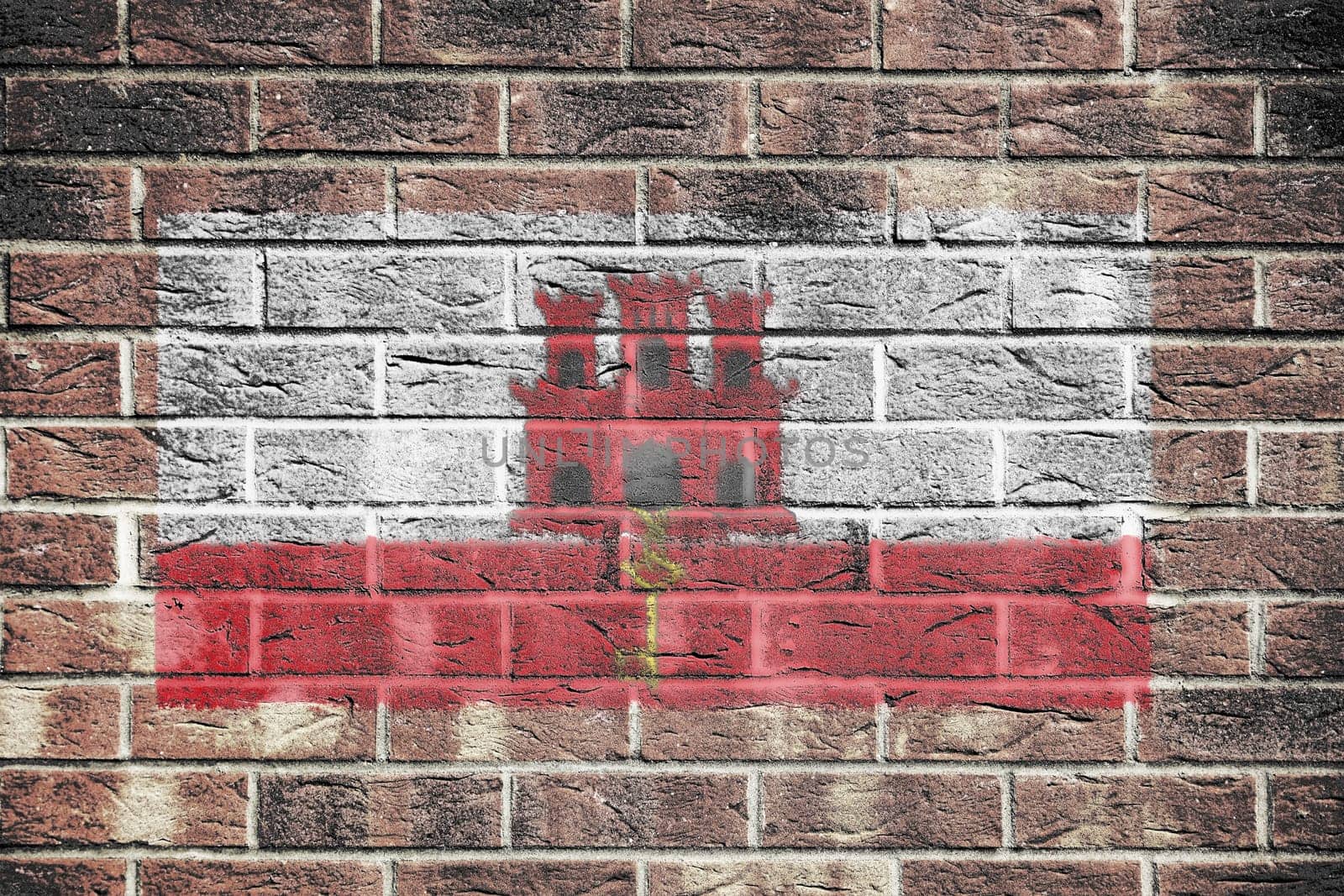 A Gibraltar flag on brick wall background