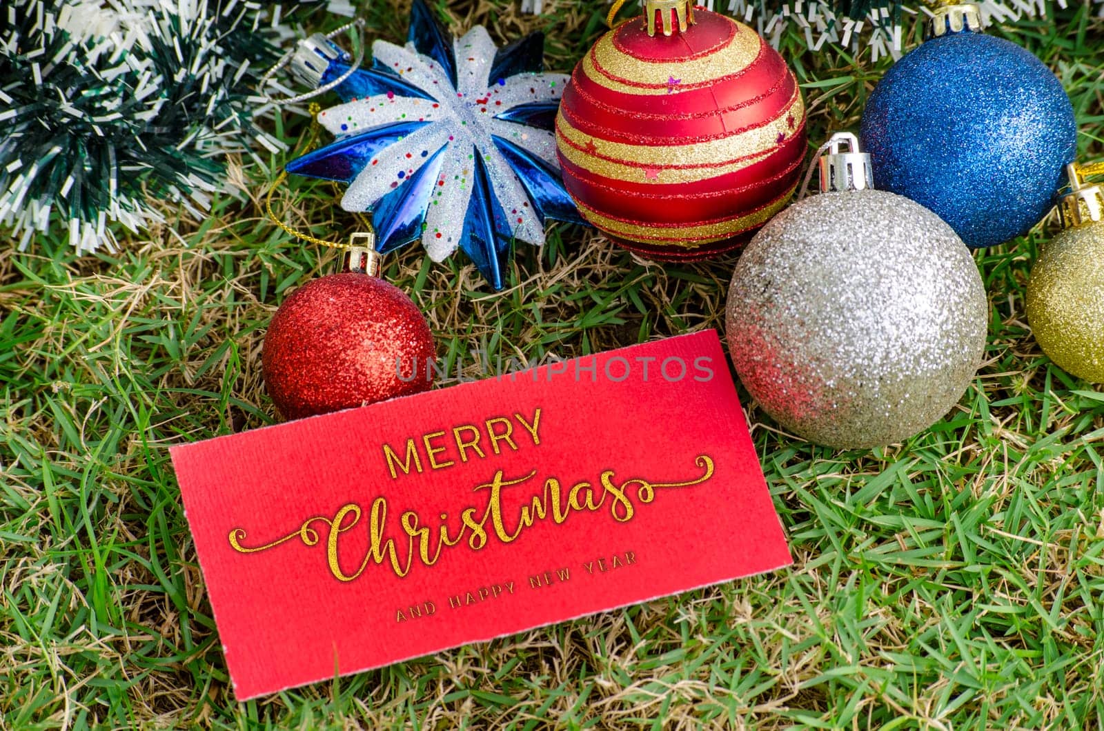 Top view of Golden Merry Christmas and Happy New Year text on red paper card with Christmas decoration background