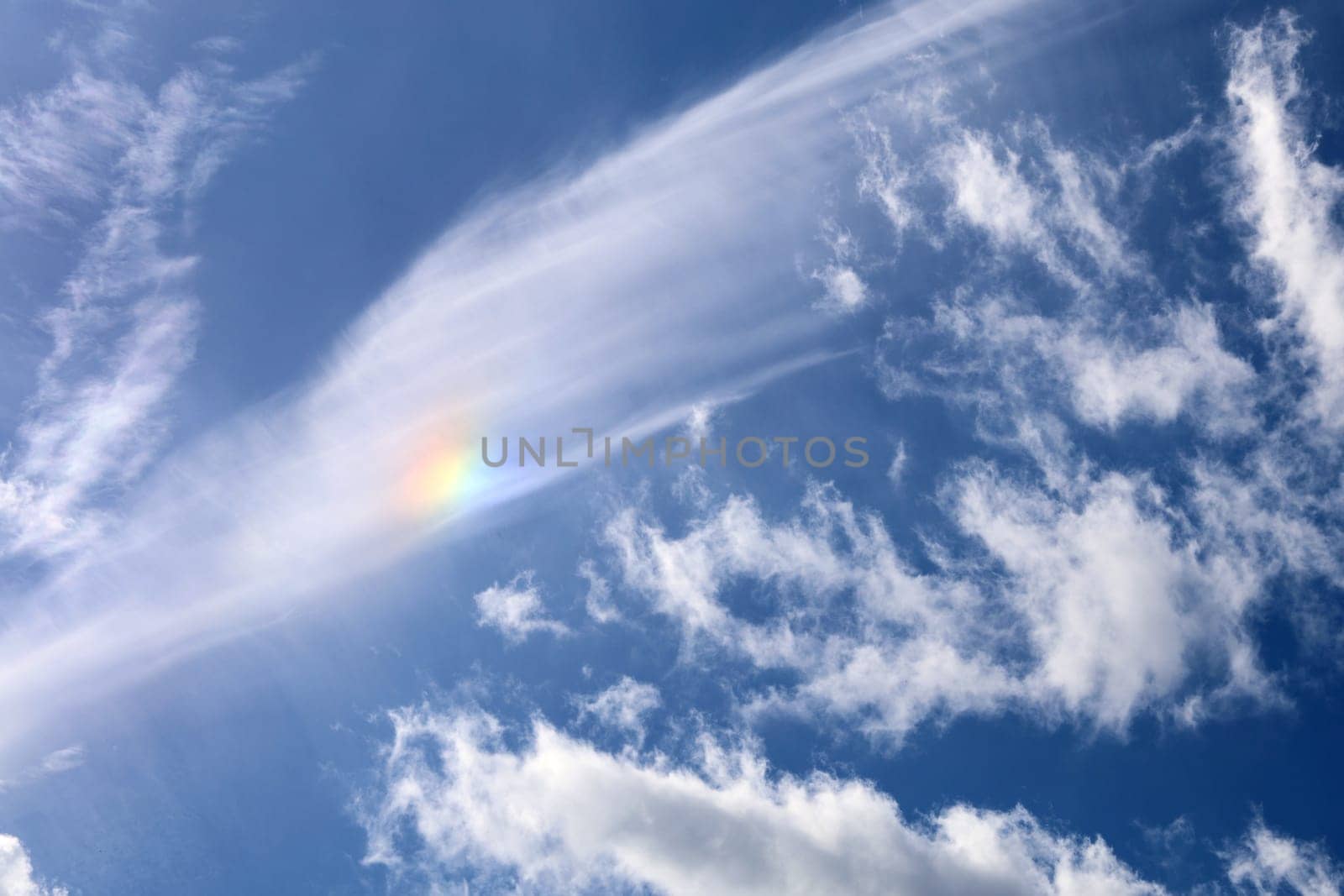 rare meteorological occurrence of a mock sun as it is forming in the clouds