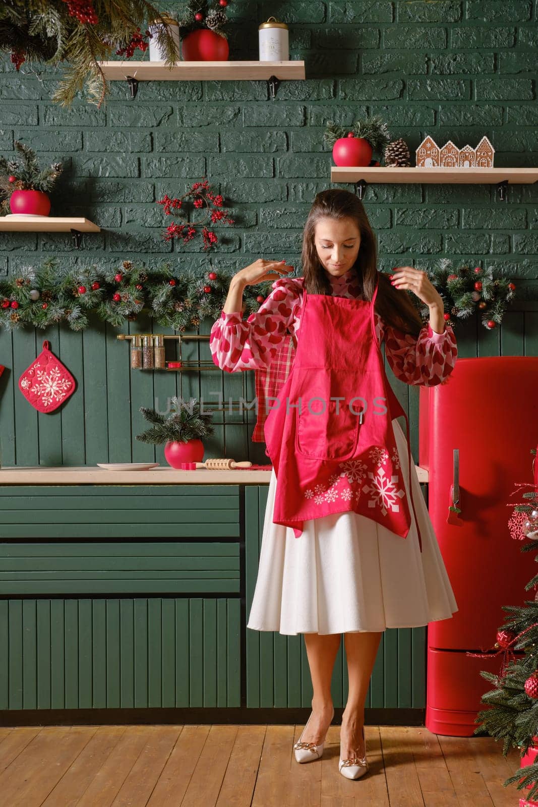 Woman puts on an apron getting ready to cook a holiday dinner in the kitchen