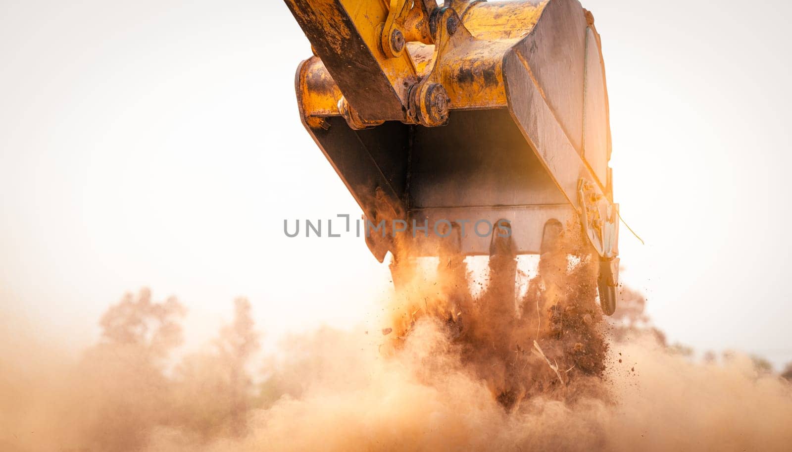 Backhoe working by digging soil at construction site bucket of crawler excavator breaking ground for new development project earth moving machine in action. Foundation work on construction project.