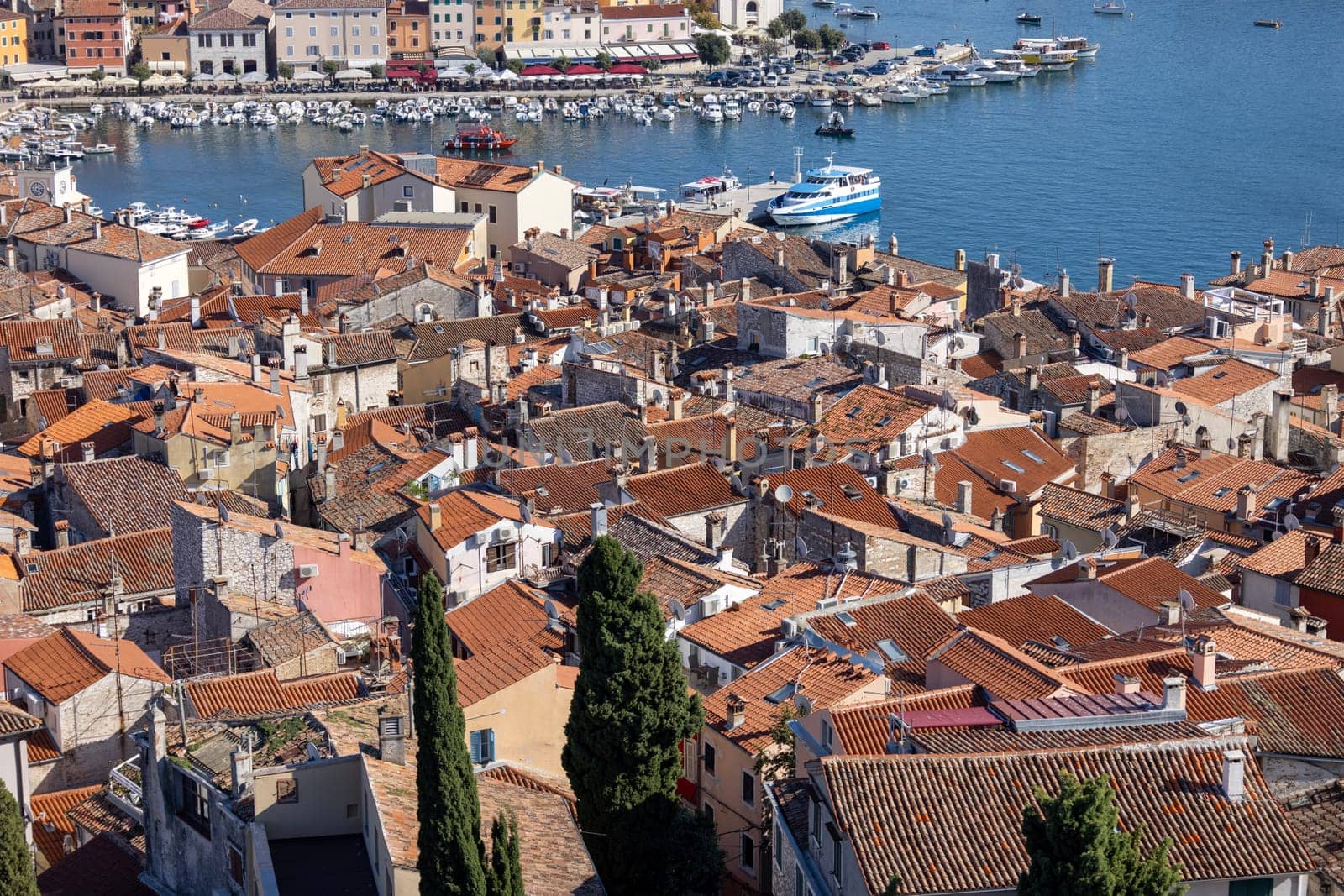 Rovinj  Croatia  Istria - September 29  2023: Aerial view from bell tower of Saint Euphemia Church of port with moored boats. Typical red ceramic roof tile