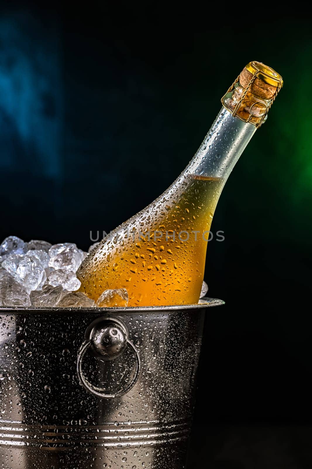 Bottle of sparkiling wine in bucket with crushed ice.