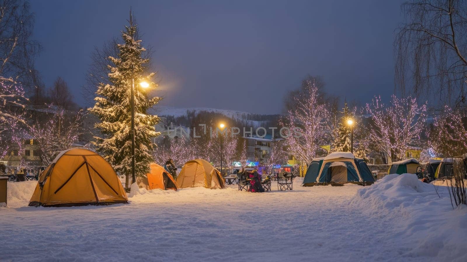 Colorful tents are set up in a snowy area lit by festive lights during twilight creating a magical winter atmosphere for campers.