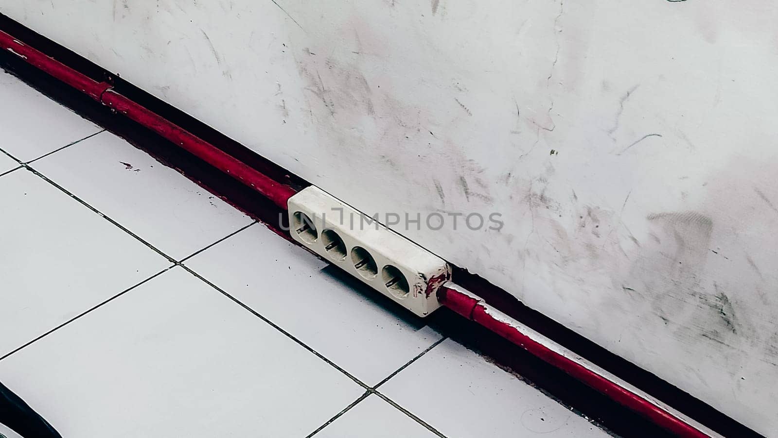 A red and white striped object is on the floor. The red stripe is on the bottom of the object