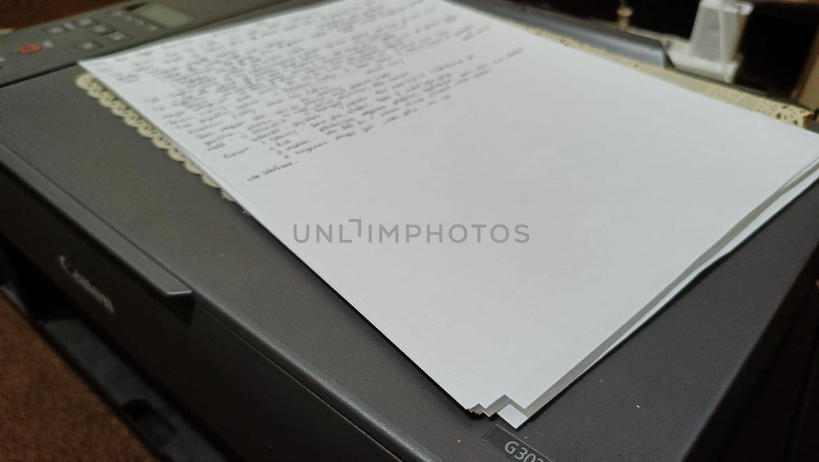 Close-up of a stack of printed papers resting on an office printer tray, highlighting everyday office tasks and technology. Suitable for illustrations about printing, office work, and document management.