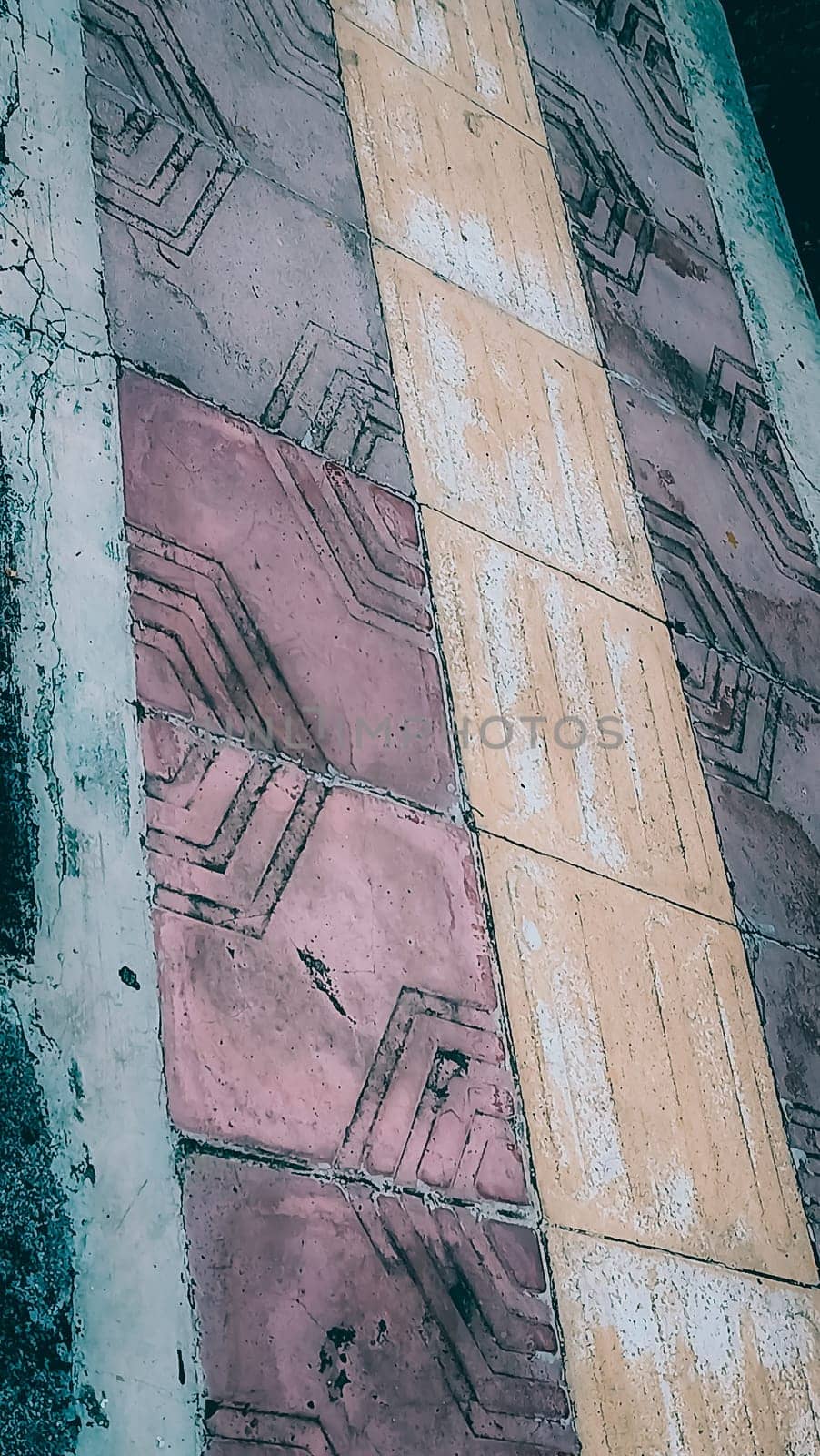 A vibrant geometric pattern of sidewalk tiles in contrasting colors of red and yellow. The detailed texture and design enhance urban aesthetics and architectural interest.