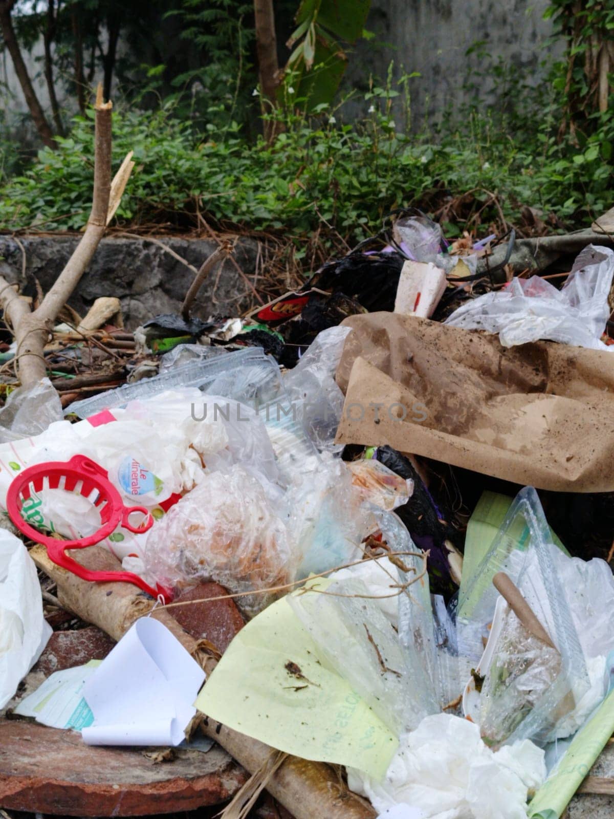 Image showcasing discarded waste, including plastics and paper, in a natural setting. Highlights the environmental impact and challenges of pollution. Emphasizes the need for proper waste management.