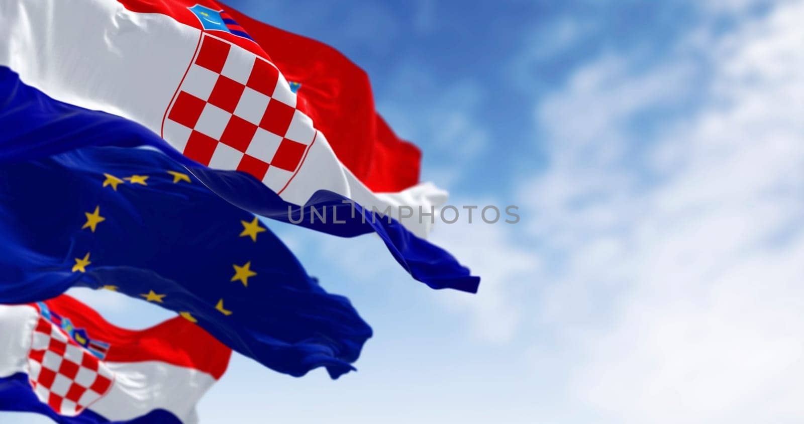 Flags of Croatia and the European Union fluttering together on a clear day. 3D illustration render. Fluttering fabric. Selective focus