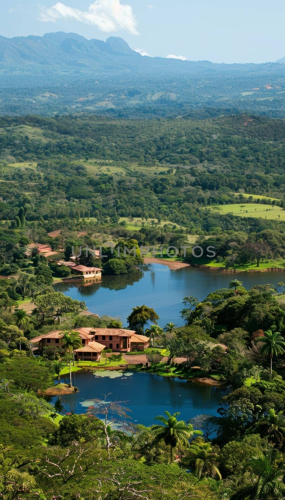 Aerial view of luxury villas nestled in lush forest overlooking blue lakes