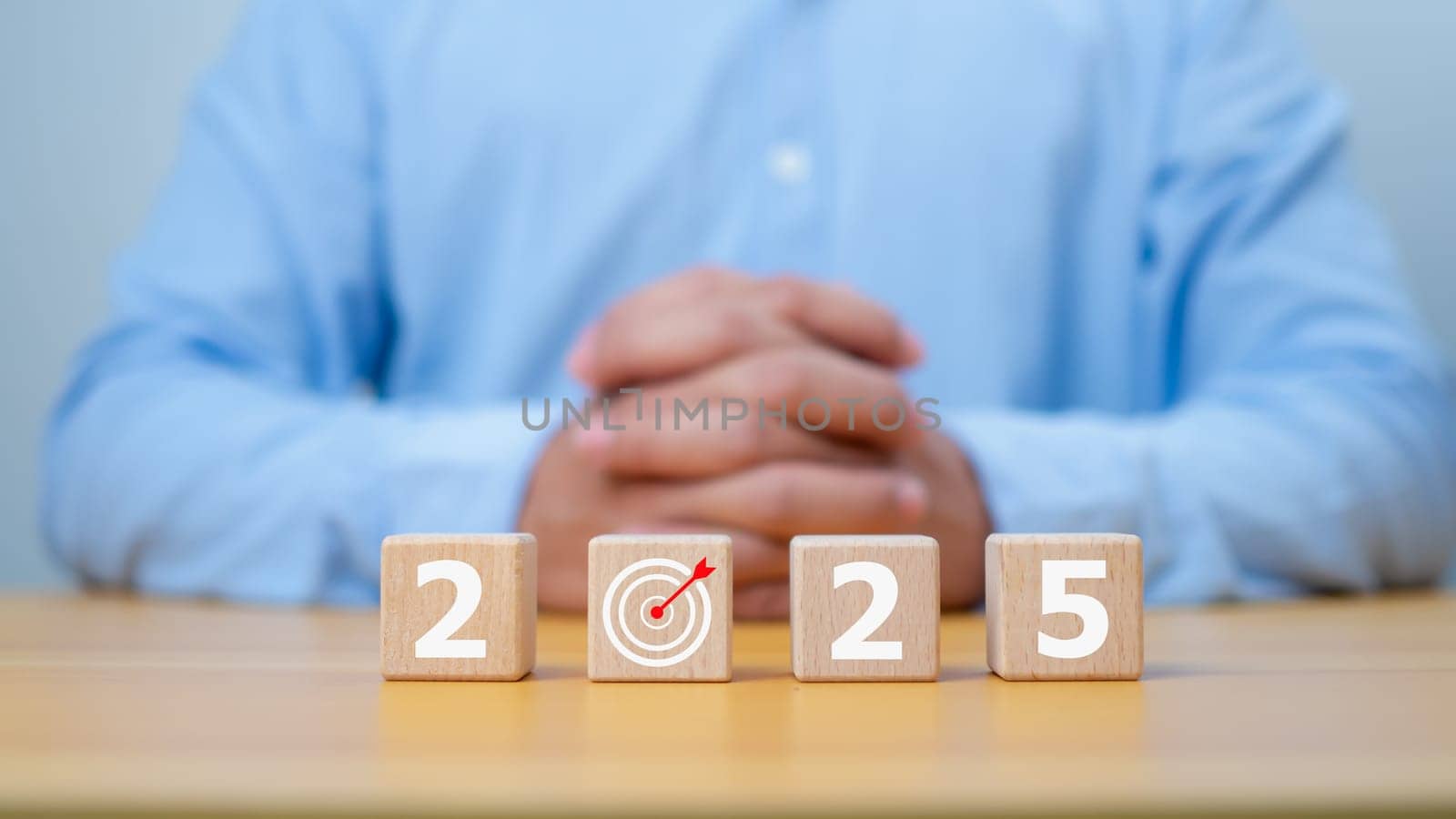 Businessman showing wooden cube from 2025. New year resolution, goal, plan, and action concept. Target plan and mission annual. Happy new year 2025 background with goal icon.