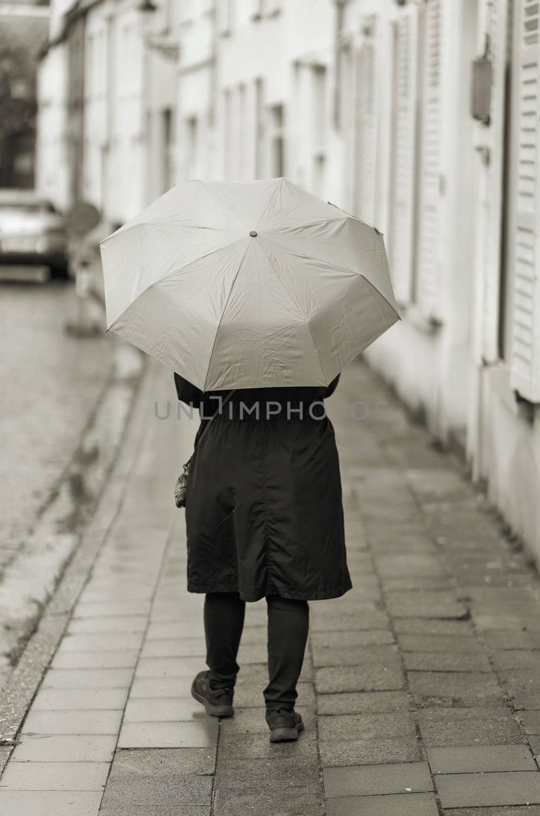 Woman with umbrella in rainy weather in the old town of Bruges in Belgium