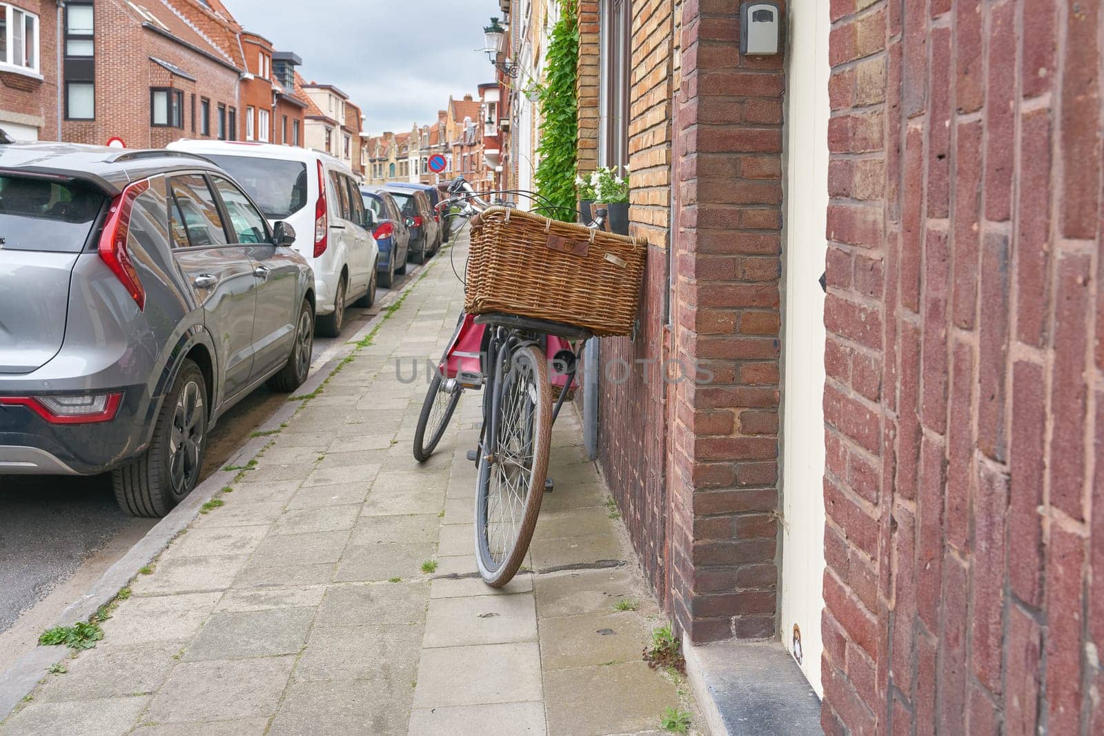 Street in the old town of Bruges in Belgium with a parked bicycle against a house wall