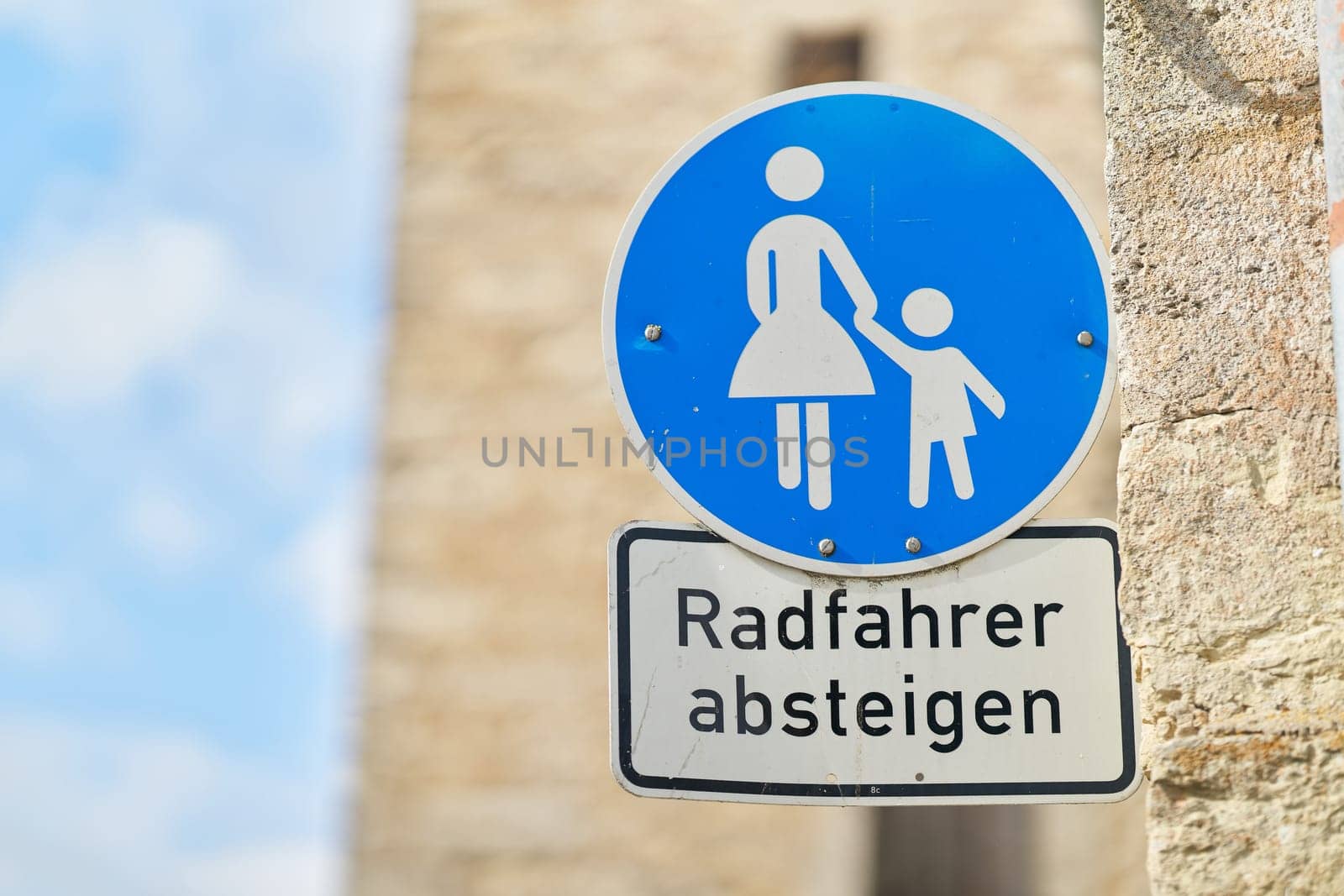 Sign in a pedestrian zone with the German inscription Radfahrer absteigen. Translation: cyclists dismount