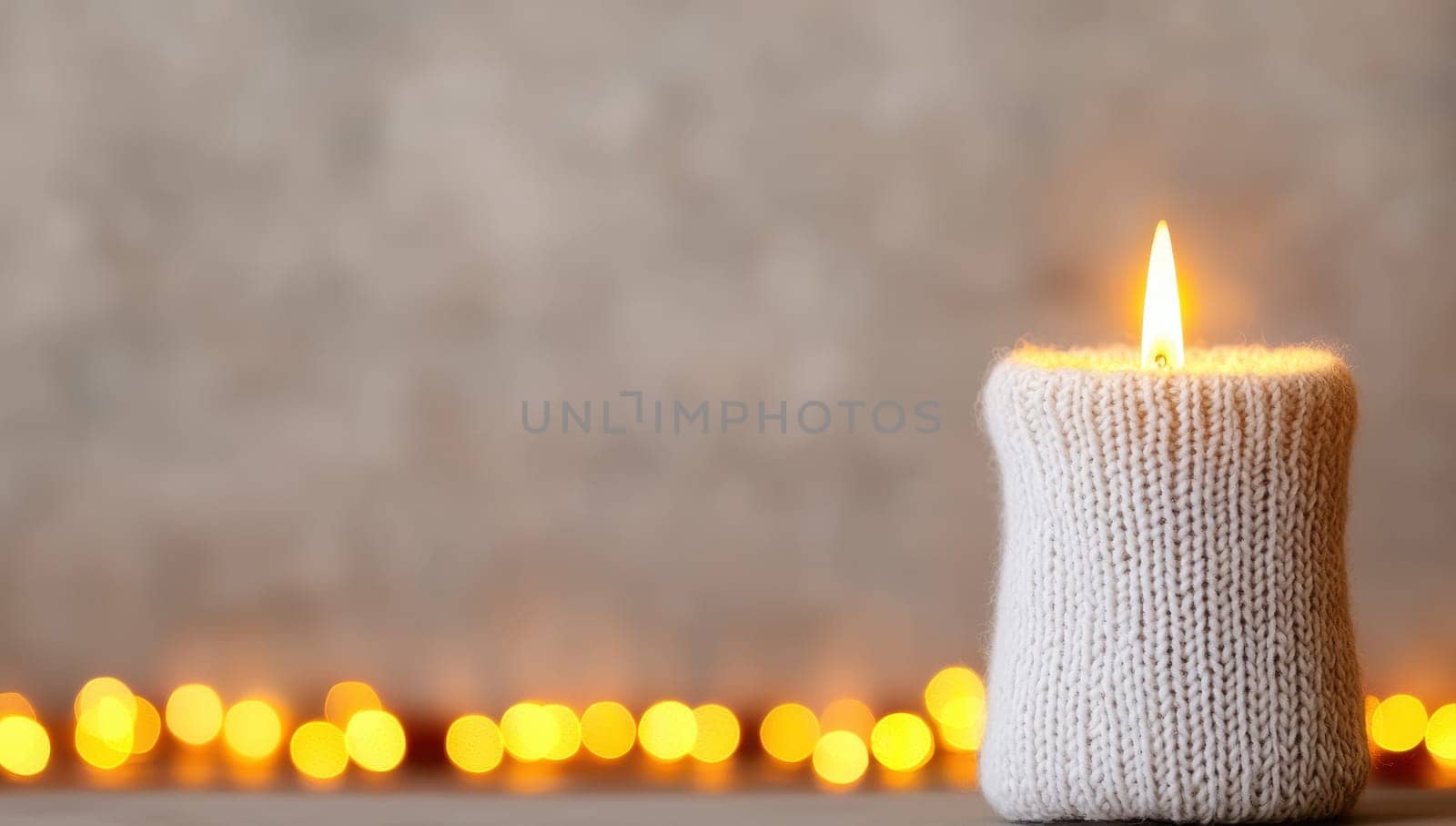 Cozy candle in knitted cover. Concept of warmth, comfort, and winter holidays.