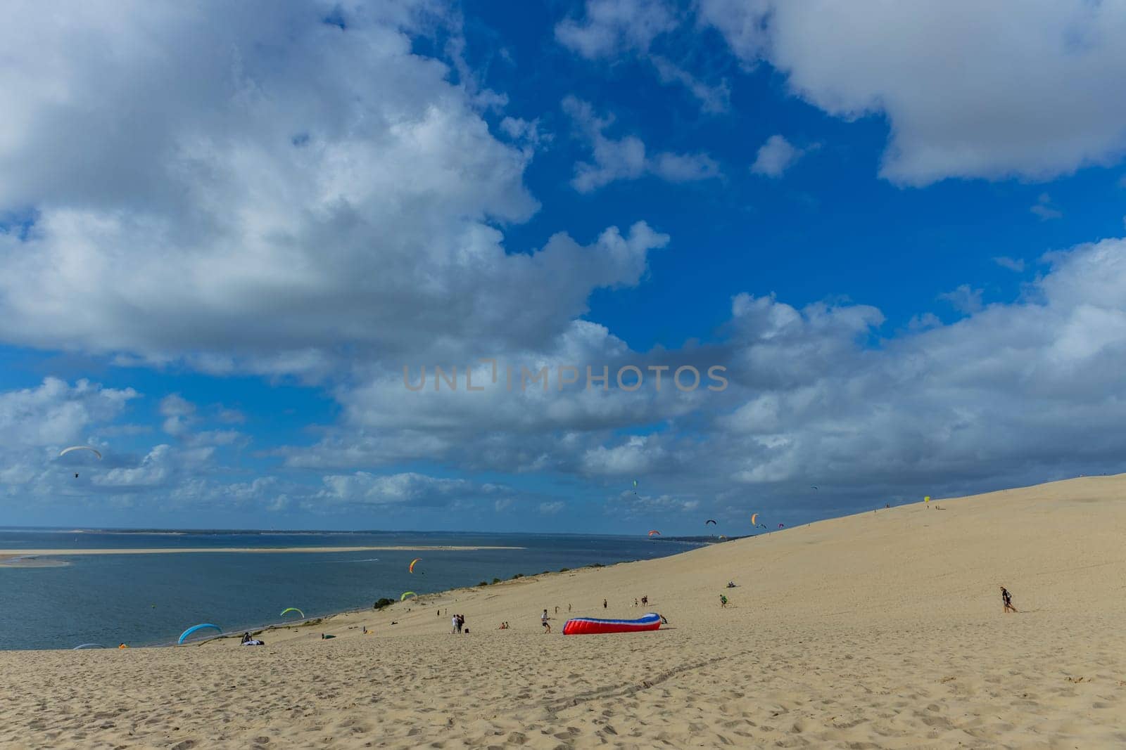 Dune of Pilat, France - August 14, 2024: People paragliding at the Great Dune of Pilat, Arcachon Basin, Nouvelle Aquitaine, France.