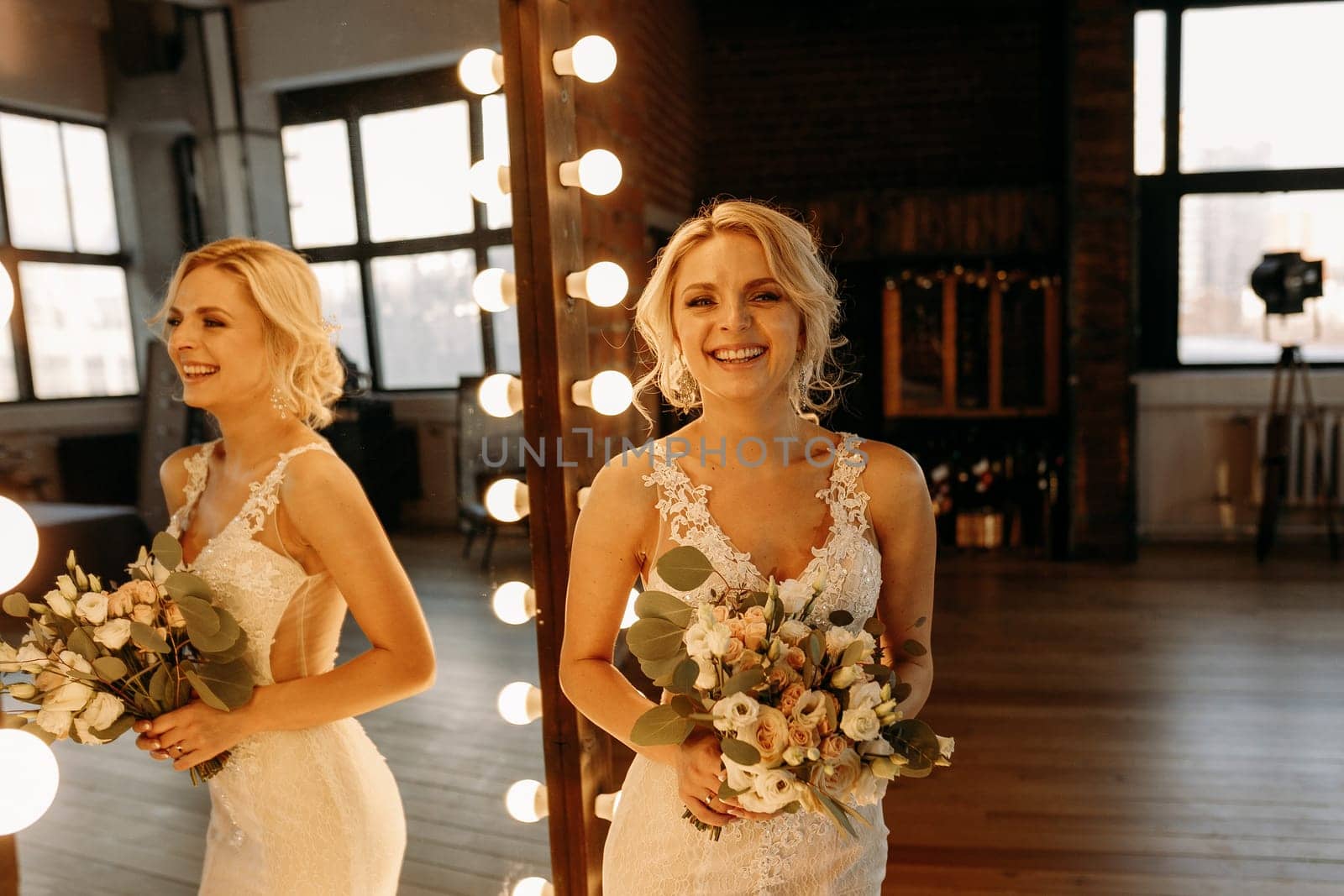 In a beautiful studio, a joyful bride poses gracefully, showcasing her stunning gown and lovely bouquet