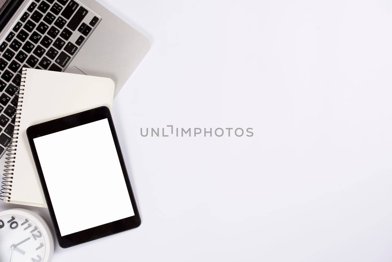 overhead view digital tablet notepad laptop with alarm clock isolated white background. High resolution photo