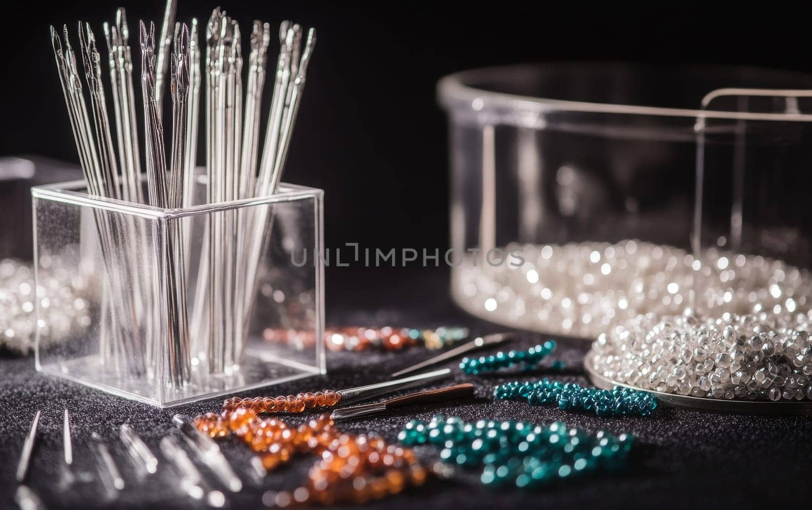 Assortment of colorful beads, needles, and jewelry making tools arranged on dark background, showcasing craft supplies for DIY accessories and handmade jewelry.