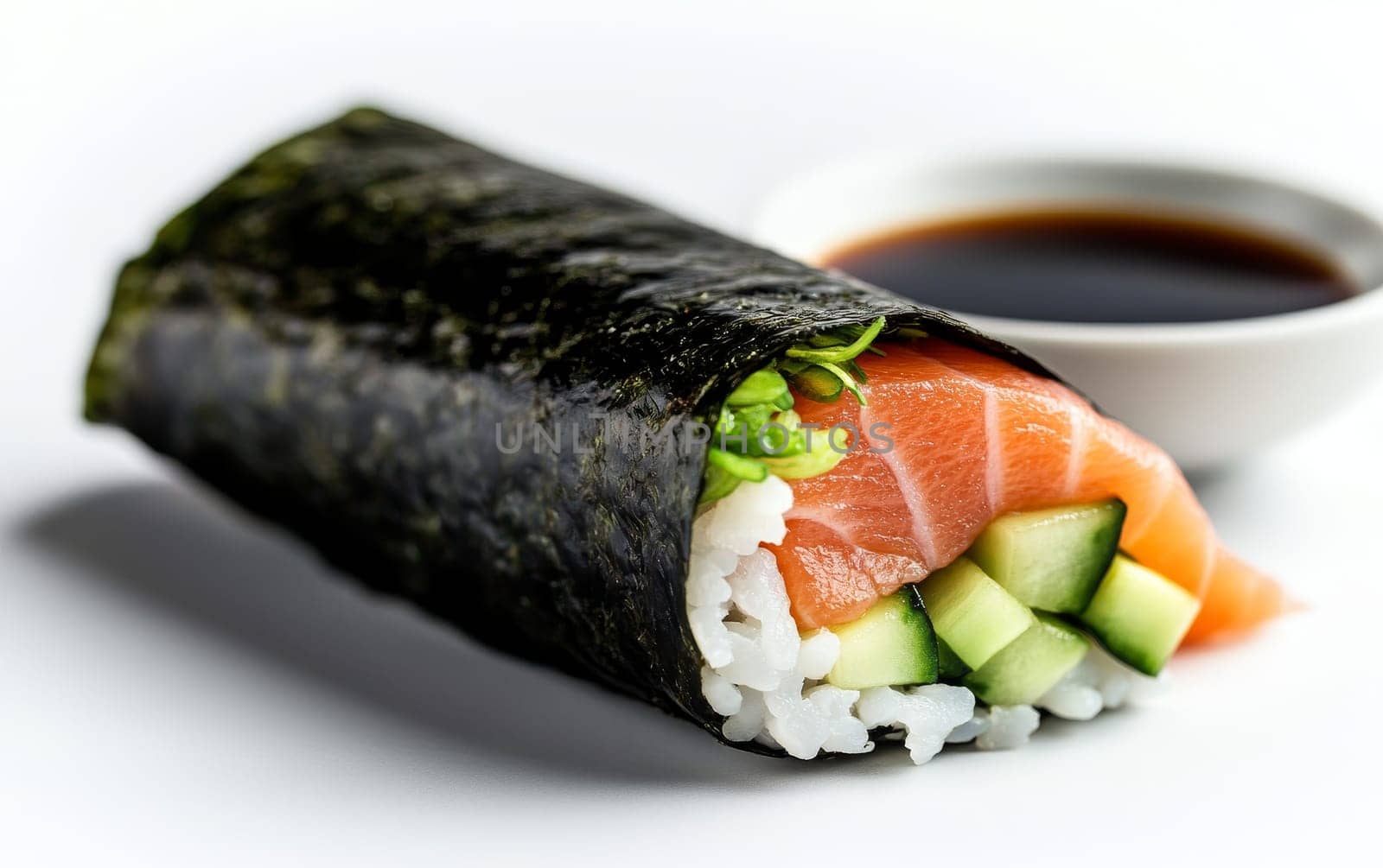 A fresh salmon sushi roll with cucumber and rice, served with a side of soy sauce for dipping.