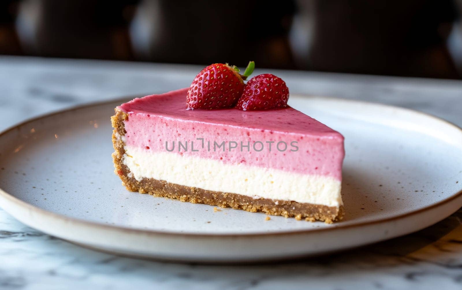 A delectable slice of strawberry mousse cheesecake with a graham crust and fresh strawberries on top.