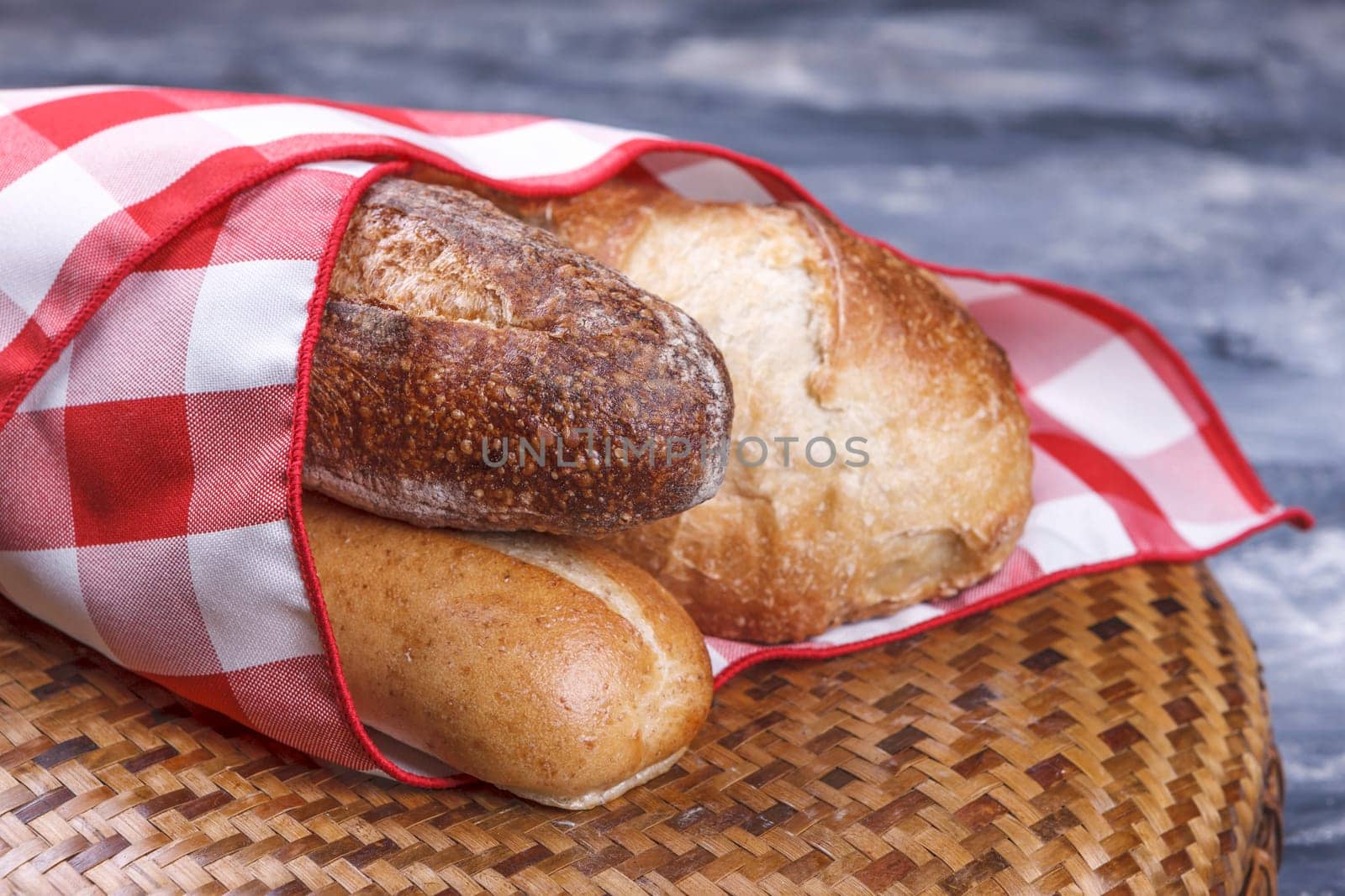 A close up of french bread and baguette wrapped up in a napkin.