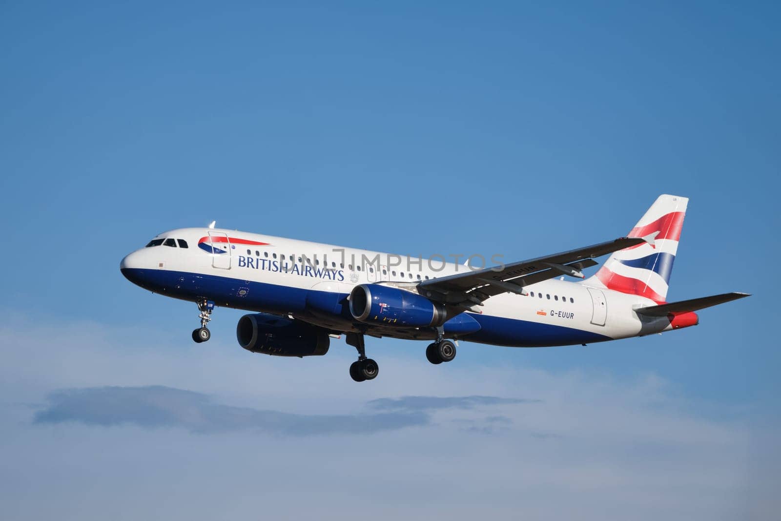 Lisbon, Portugal - September 2, 2023: British Airways Airbus A320-232 passenger plane descends for landing in blue sky in Humberto Delgado Airport in Lisbon