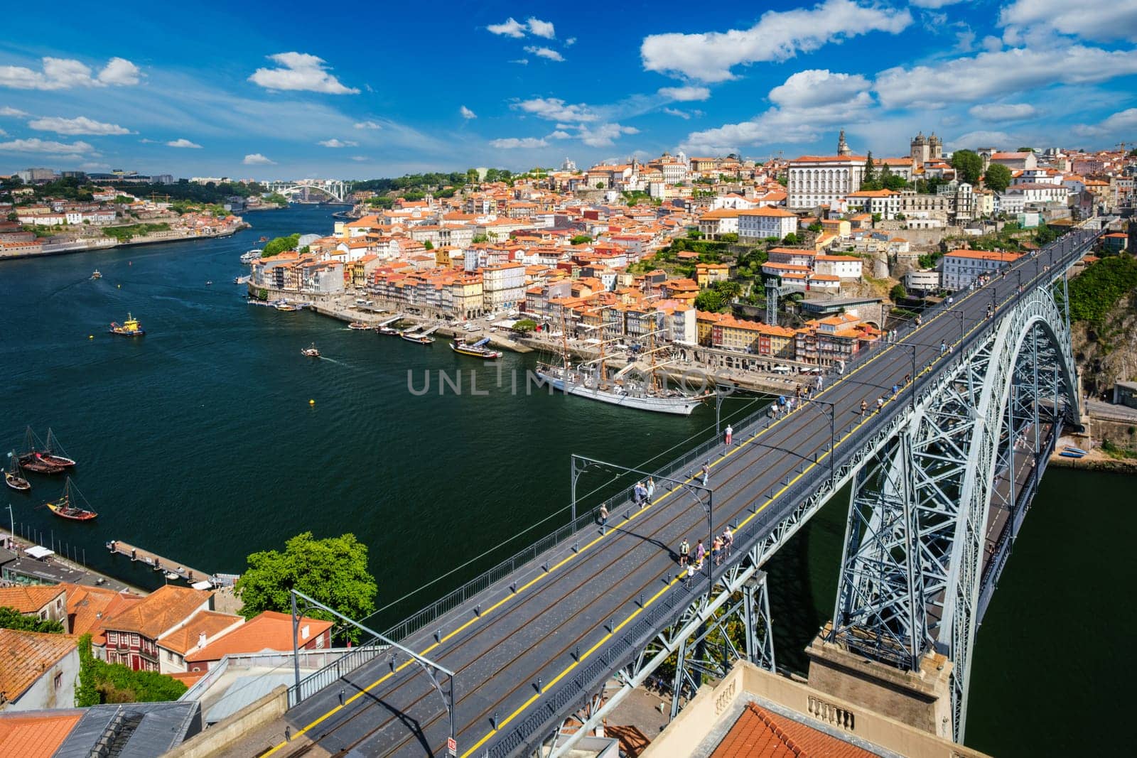 View of Porto city and Douro river with moored sailing ship and Dom Luis bridge I from famous tourist viewpoint Miradouro da Serra do Pilar on sunset. Porto, Vila Nova de Gaia, Portugal