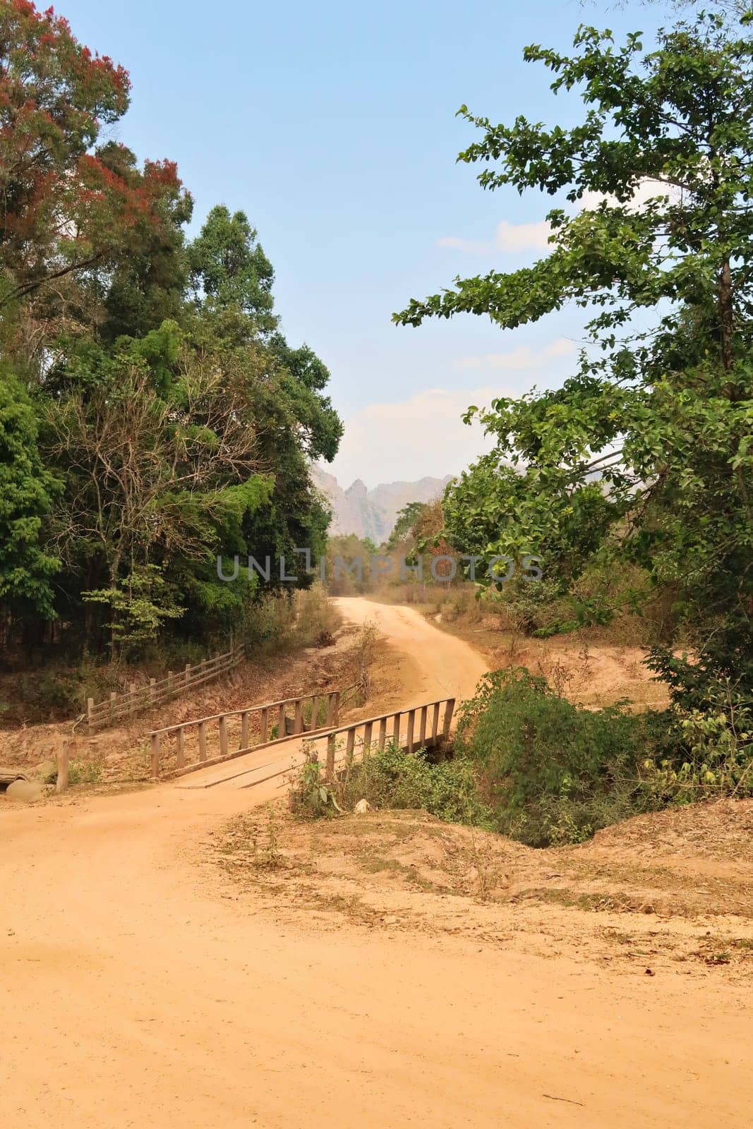 A windy dirt road leading to the village Ban Natane on the other side of Kong Lor Cave, a tourist attraction on the Thakhek Motorbike Loop, Laos 2023