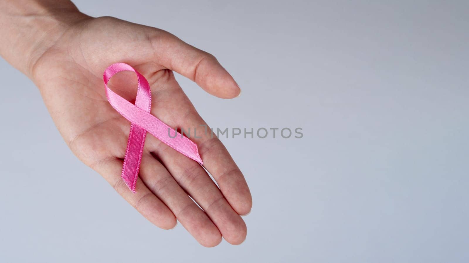 close up person holding pink ribbon. High resolution photo