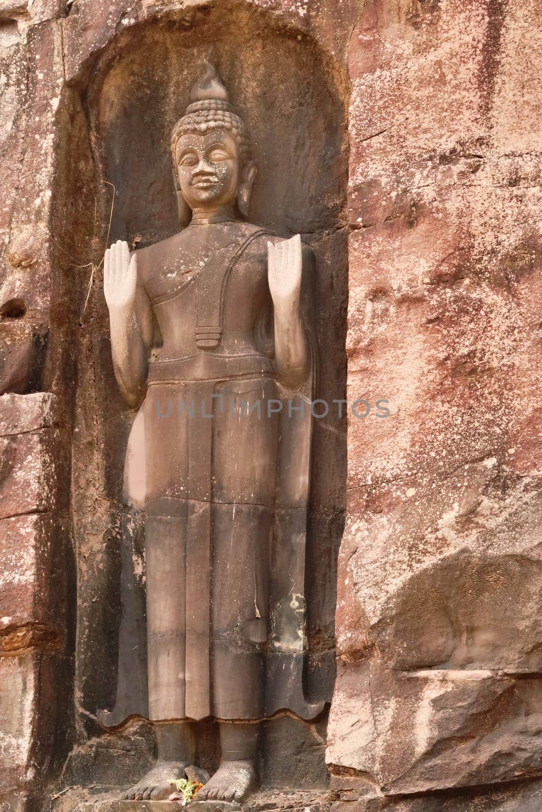 A Sandstone Buddha Rock Sculpture carved into the rock next to the road on the Thakhek Motorbike Loop, Laos 2023