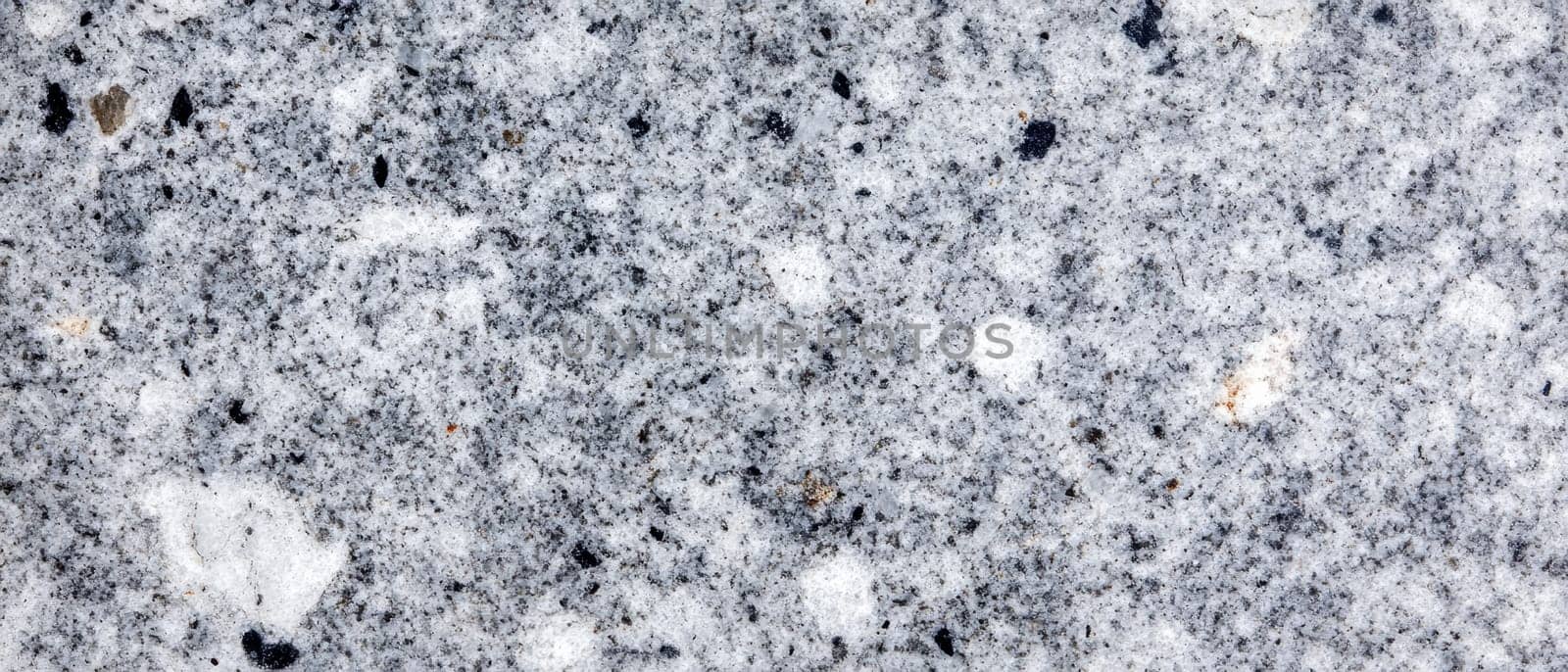 Detailed close up of gray granite surface showing natural patterns, speckles, and crystalline structure of the stone.