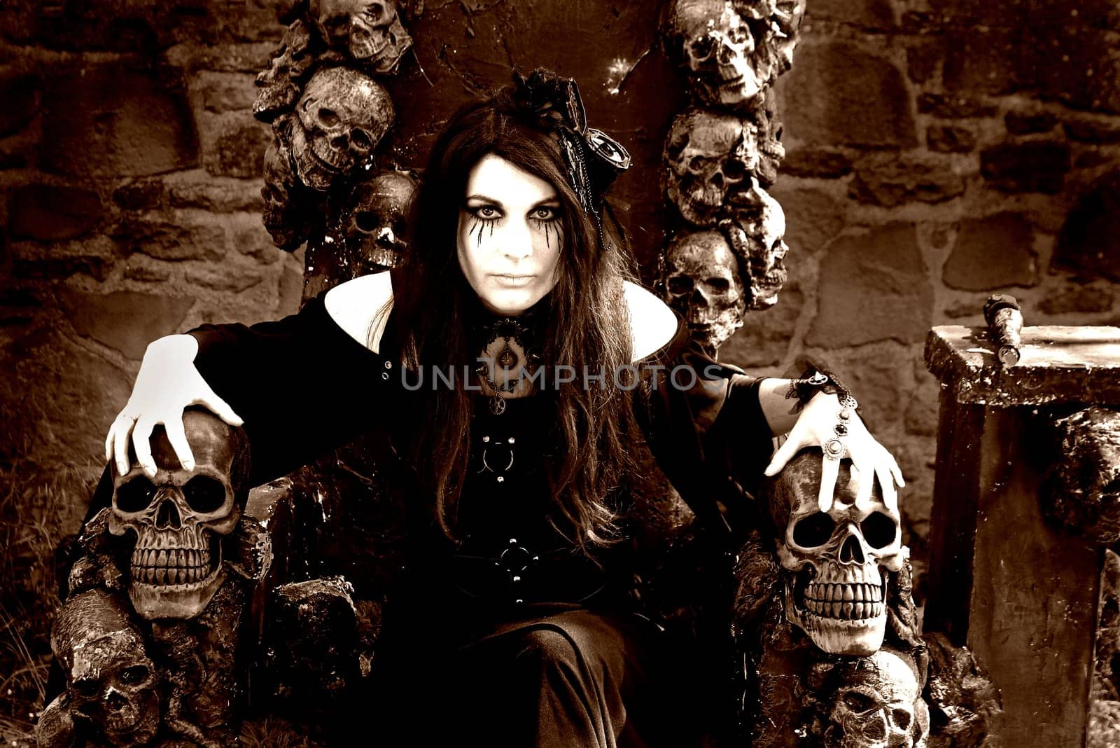 Fantasy photo with an evil witch on a throne with skulls