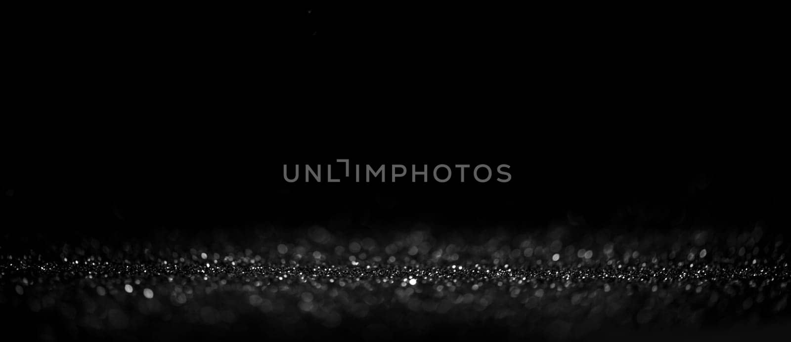 Black friday bokeh background. Elegant dark blur layout design. Silver and black glitter place on table with spotlight. Luxury abstract banner with copyspace.