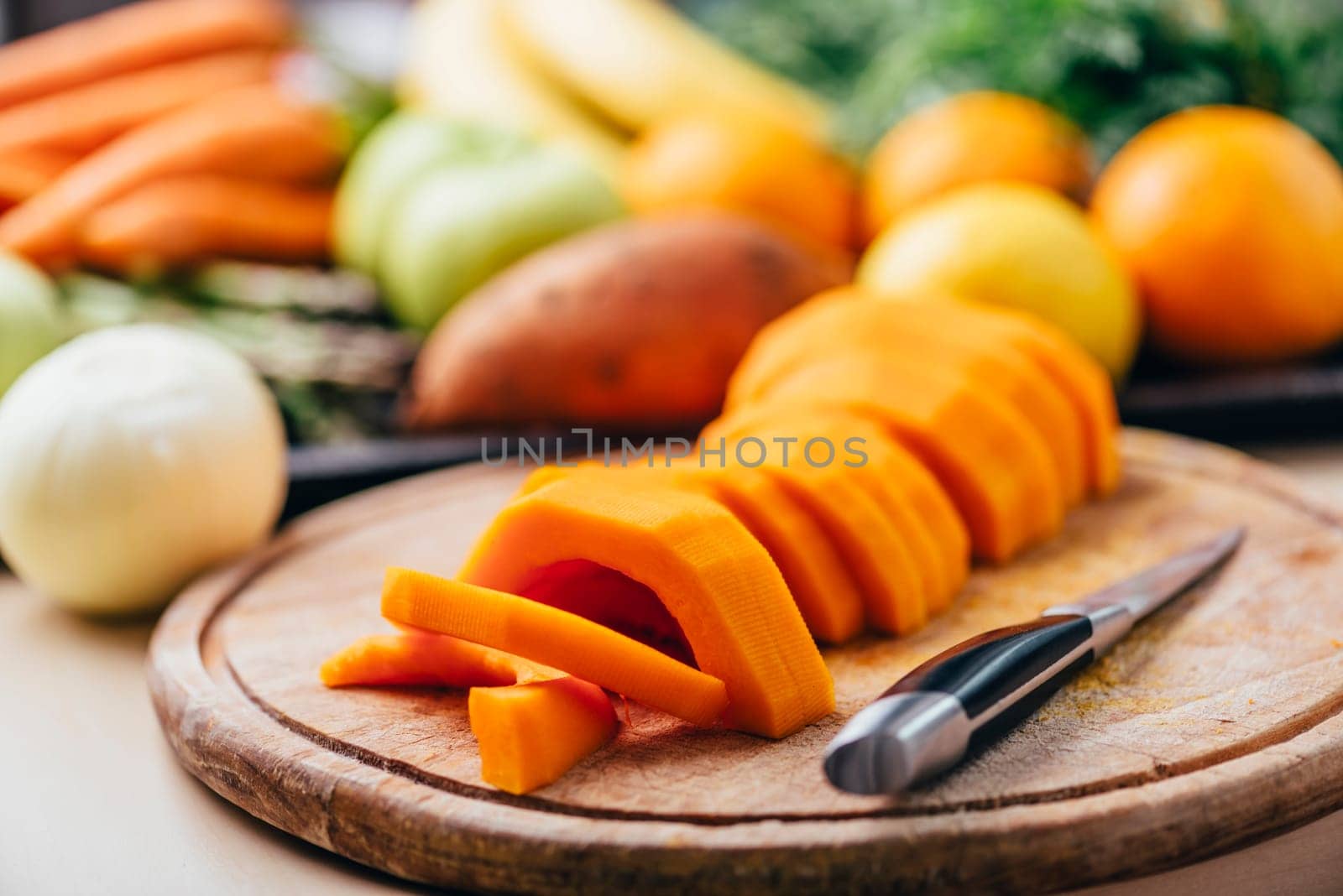 Butternut squash meal preparation on wooden kitchen table. Cooking food for traditional thanksgiving dinner. Making autumn pumpkin soup.