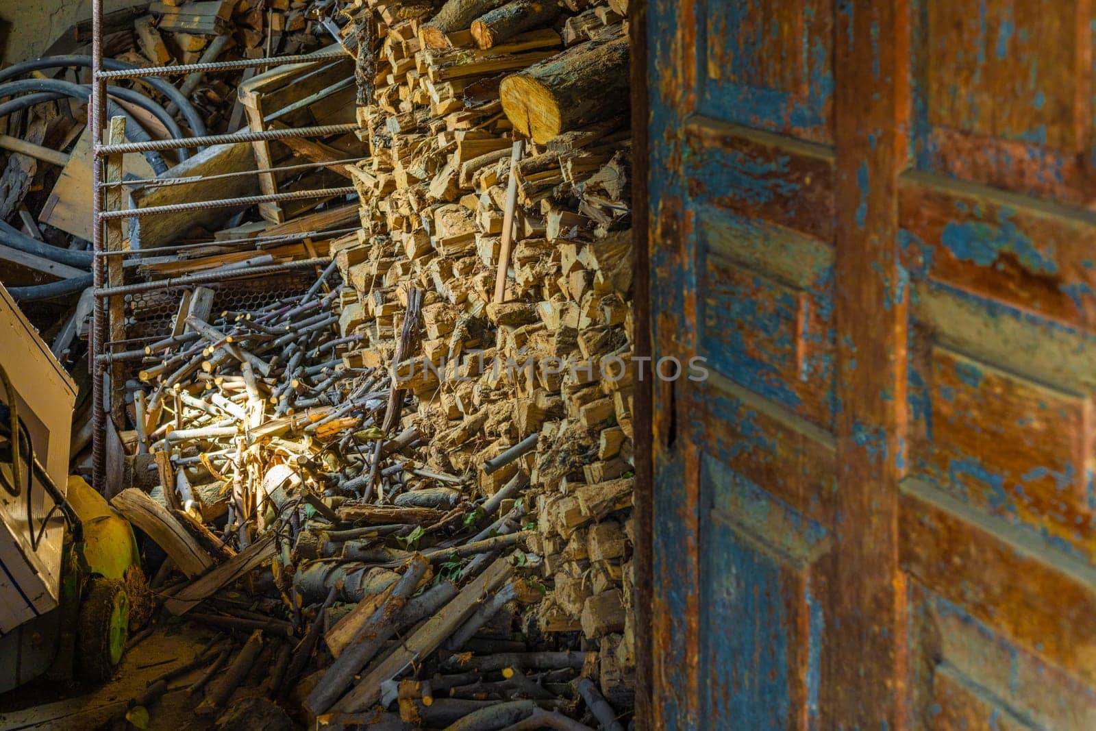 barn with chunks of firewood behind old shabby door