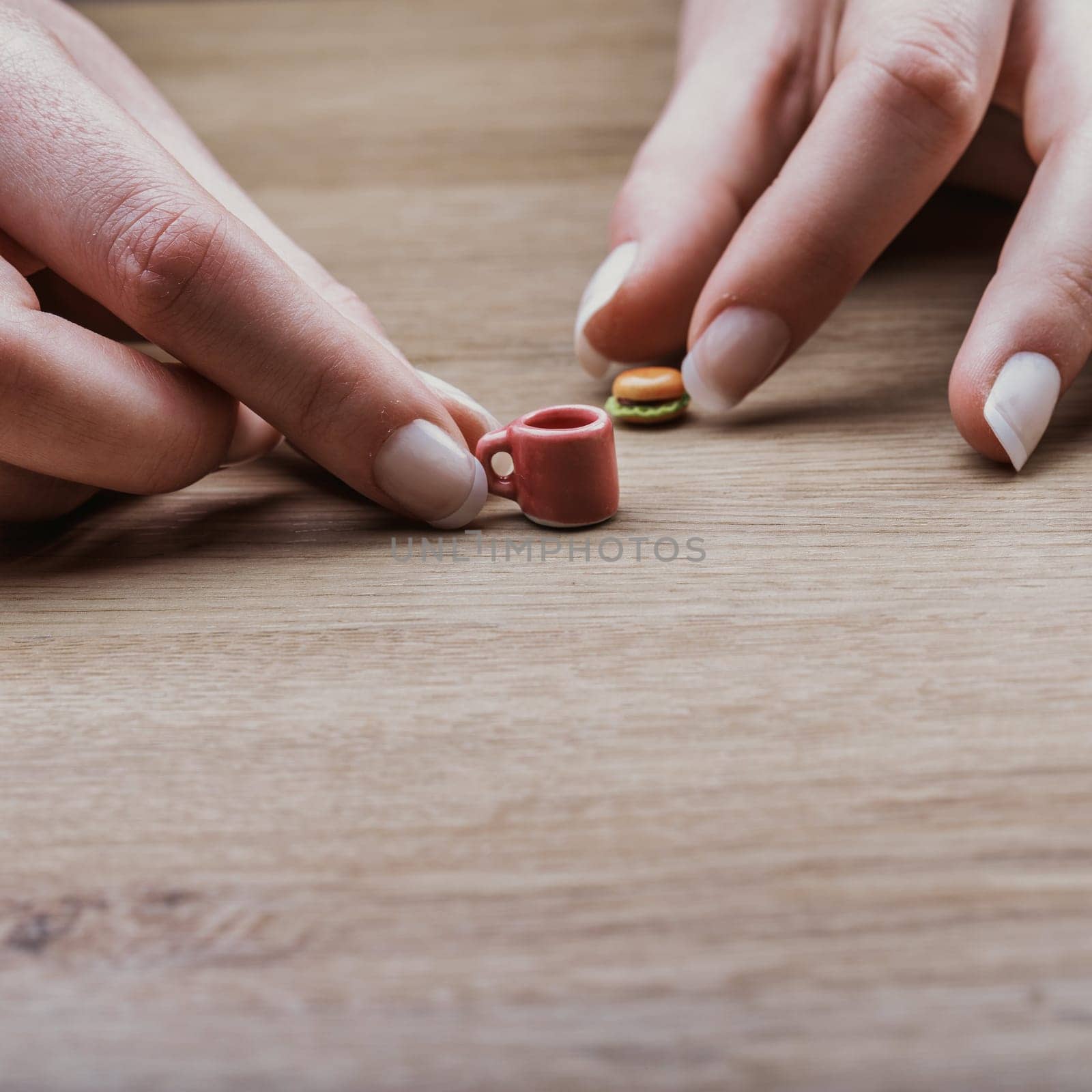Miniature burger and cup capture the difficulty of following nutritionist-approved portions. Although correct in size, these items feel tiny and unsatisfying, challenging dietary discipline