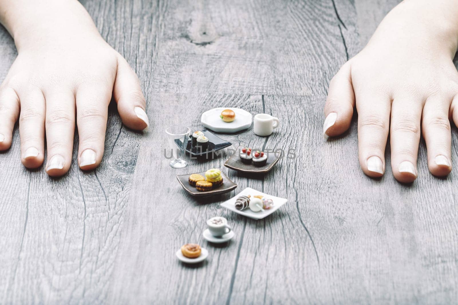Mini portions of sushi, sandwiches, and desserts visually capture nutritional discipline challenges. Though accurate in size, these tempting treats feel too small and unsatisfying, yet visually appeal