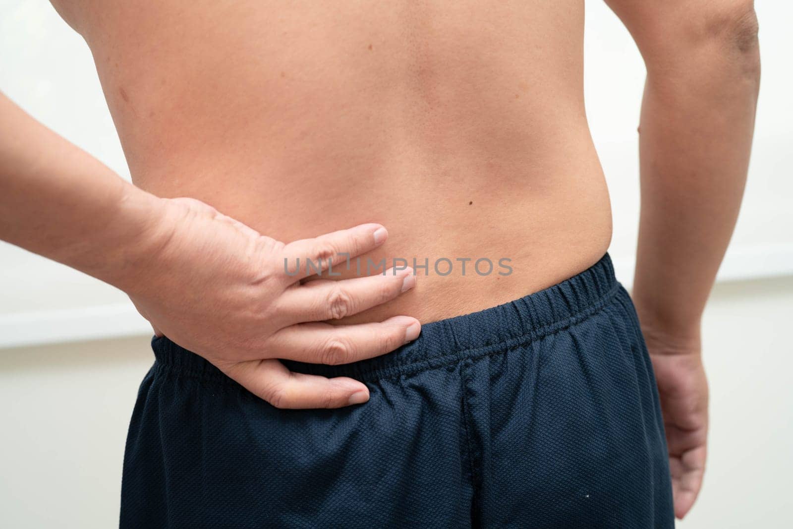 Asian man pain back muscle, spine and bone from accident.