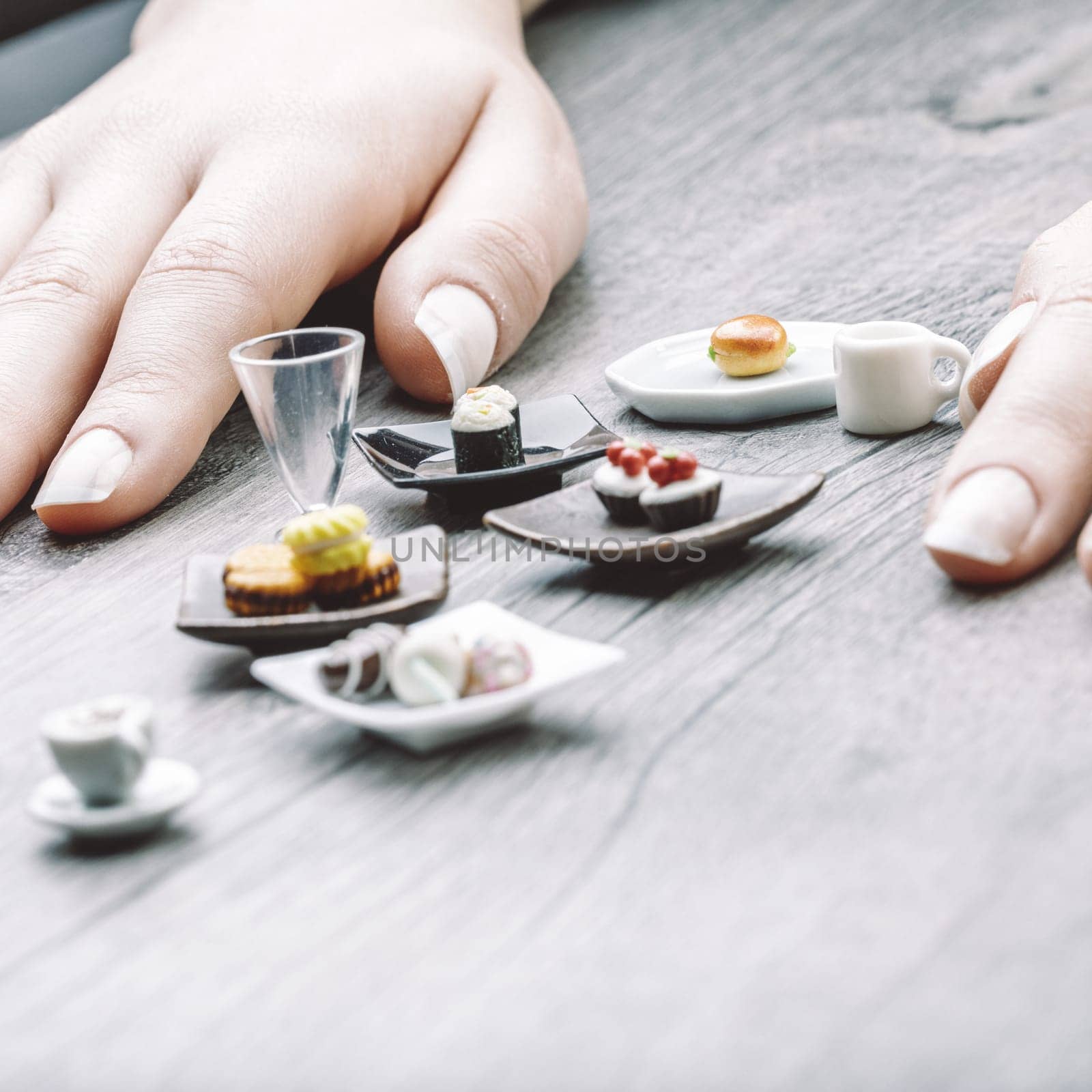 Miniature servings of coffee, pastries, and sushi illustrate portion control's tension between satisfaction and discipline. These visually appealing foods feel almost impossibly small