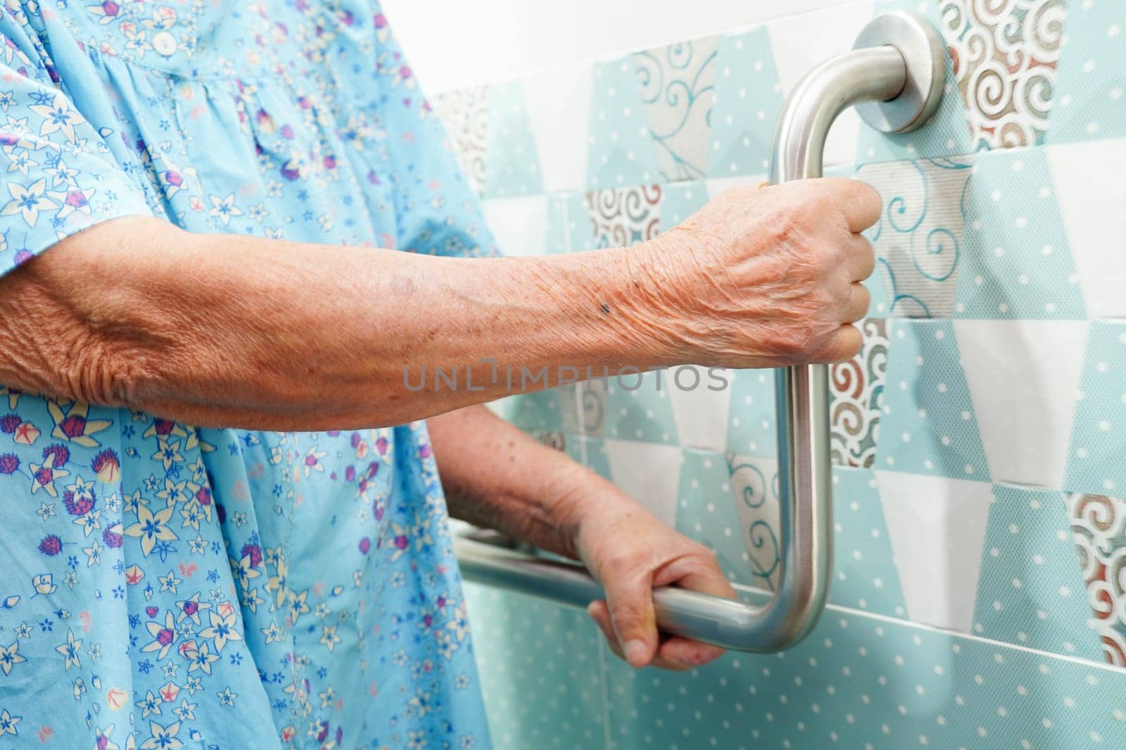 Asian elderly old woman patient use toilet support rail in bathroom, handrail safety grab bar, security in nursing hospital.