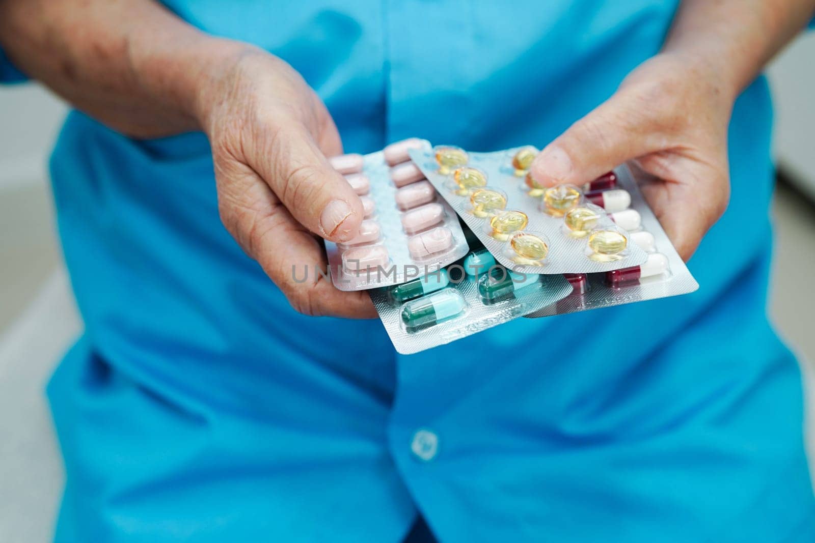 Asian elderly woman holding pill drug in hand, strong healthy medical concept.